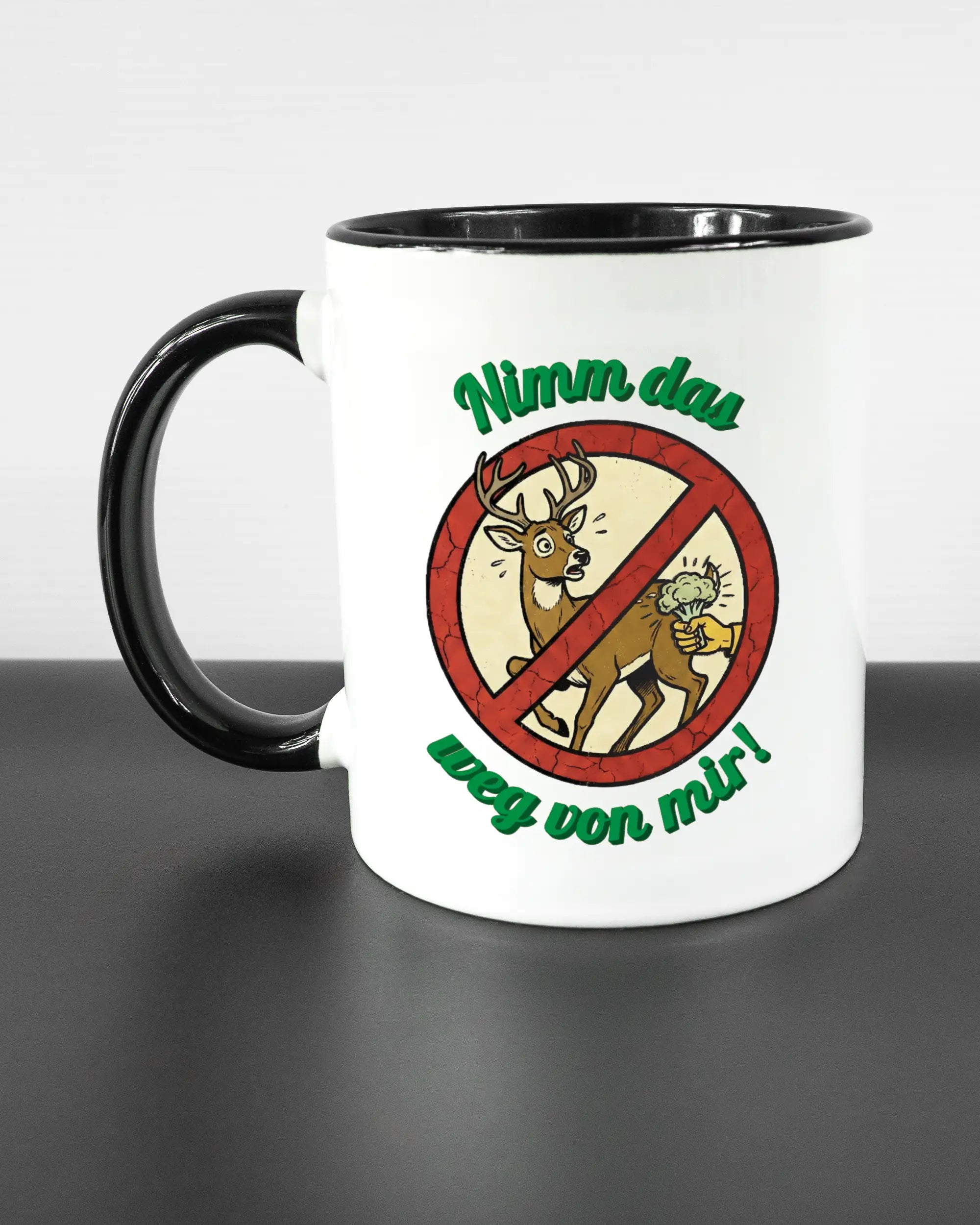 Titelbild, das die linke Seite der beidseitig bedruckten Keramiktasse von Maondo mit dem Design Reh weg in der Farbe Duotone auf einem Holztisch zeigt