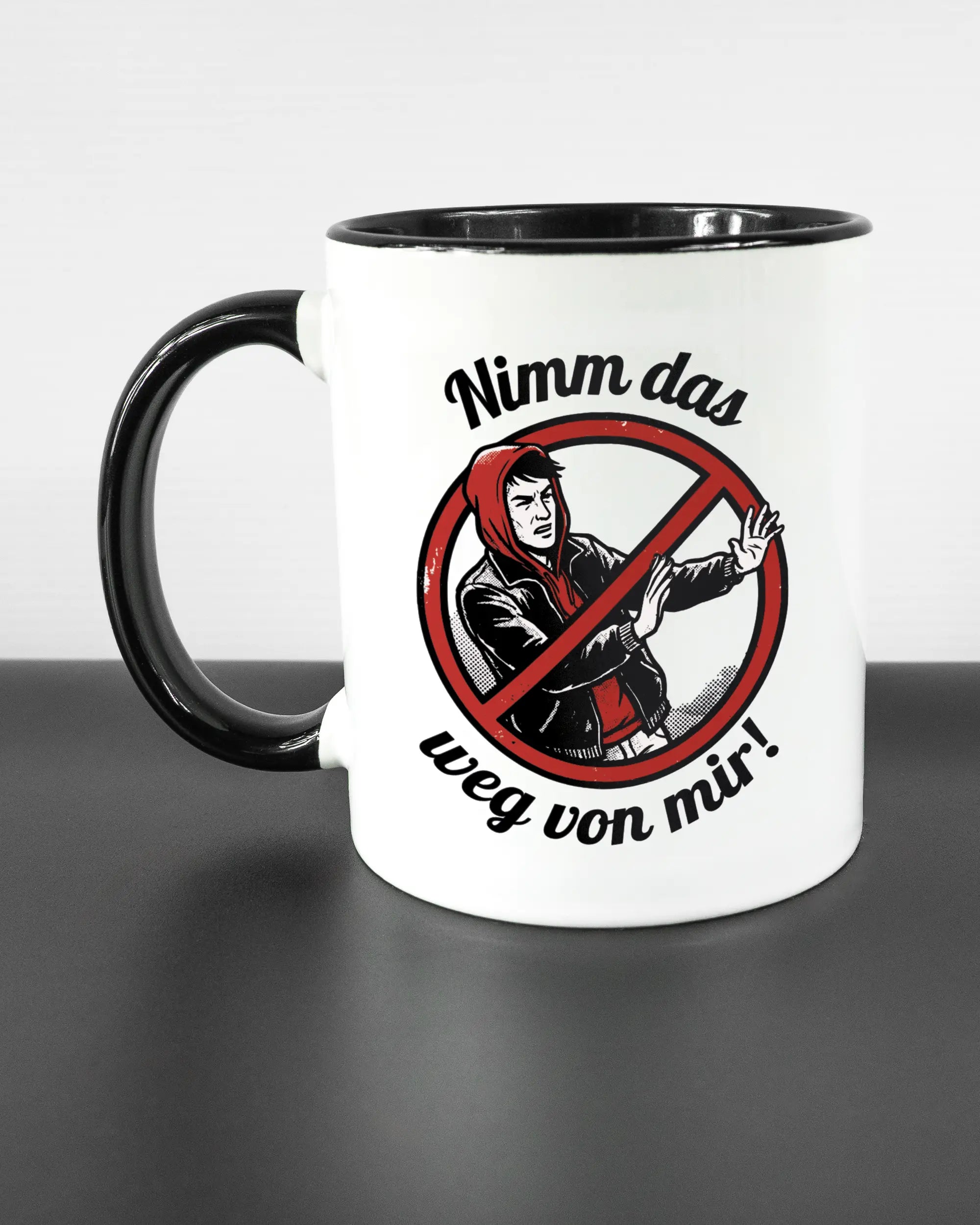 Titelbild, das die linke Seite der beidseitig bedruckten Keramiktasse von Maondo mit dem Design Nimm das weg in der Farbe Duotone auf einem Holztisch zeigt