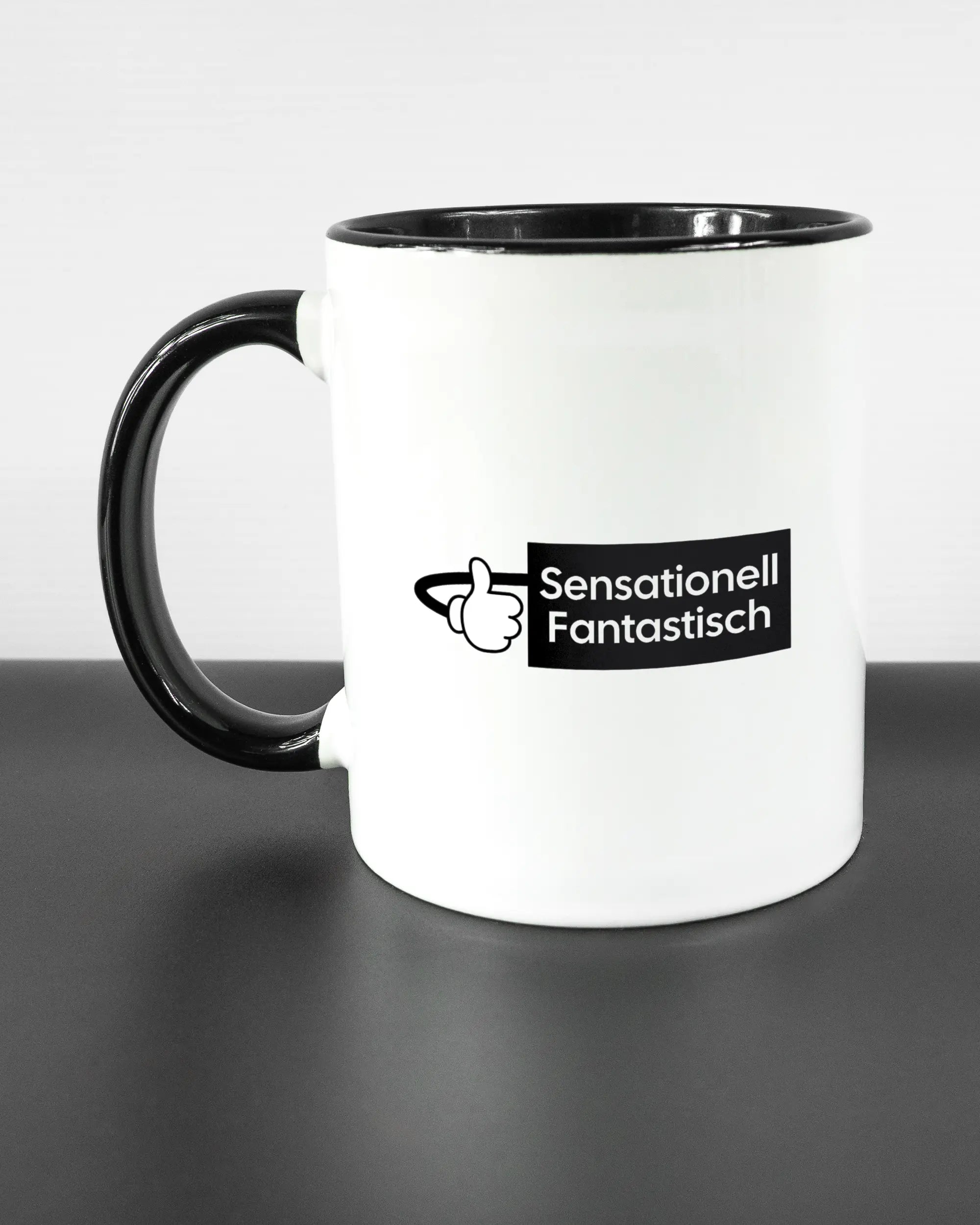 Titelbild, das die linke Seite der beidseitig bedruckten Keramiktasse von Maondo mit dem Design Fantastisch in der Farbe Duotone auf einem Holztisch zeigt