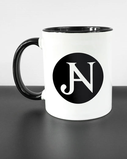 Titelbild, das die linke Seite der beidseitig bedruckten Keramiktasse von Maondo mit dem Design JB1 in der Farbe Duotone auf einem Holztisch zeigt