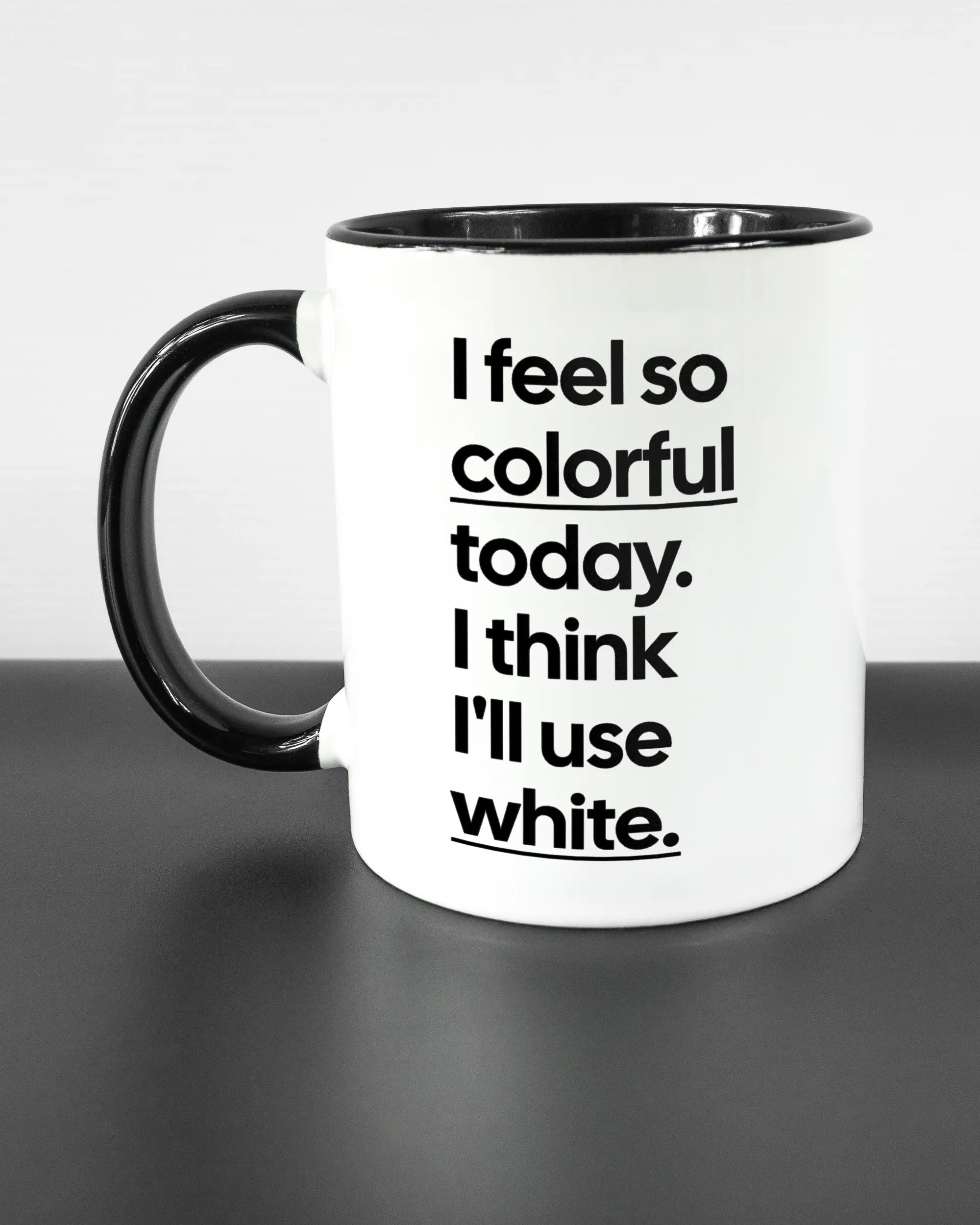 Titelbild, das die linke Seite der beidseitig bedruckten Keramiktasse von Maondo mit dem Design Colorful Day in der Farbe Duotone auf einem Holztisch zeigt