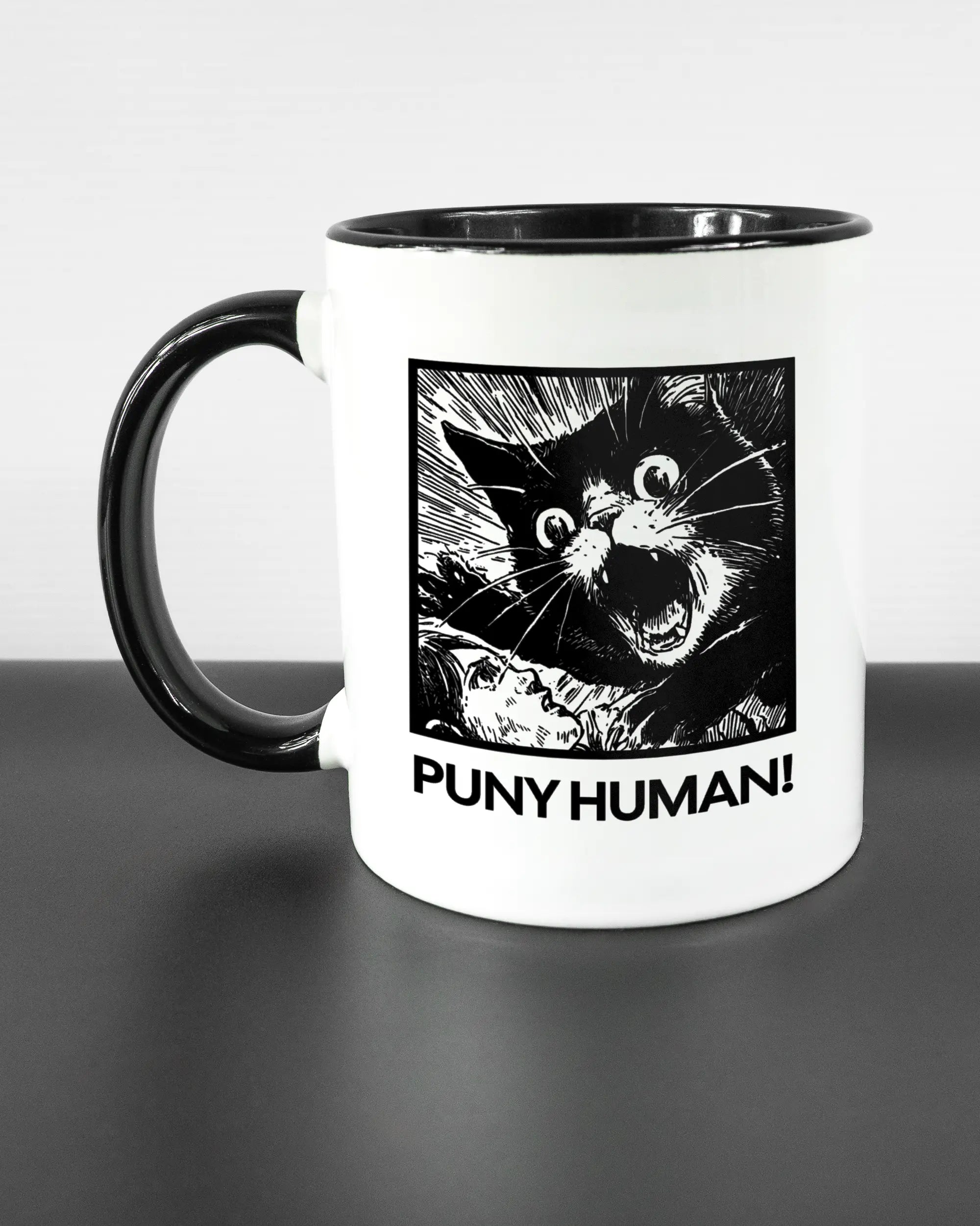 Titelbild, das die linke Seite der beidseitig bedruckten Keramiktasse von Maondo mit dem Design Puny Human in der Farbe Duotone auf einem Holztisch zeigt