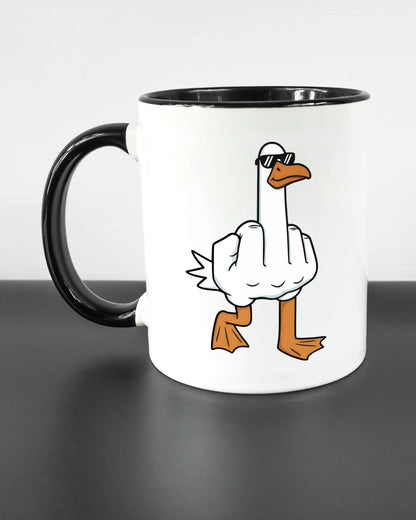 Titelbild, das die linke Seite der beidseitig bedruckten Keramiktasse von Maondo mit dem Design I give a duck in der Farbe Duotone auf einem Holztisch zeigt