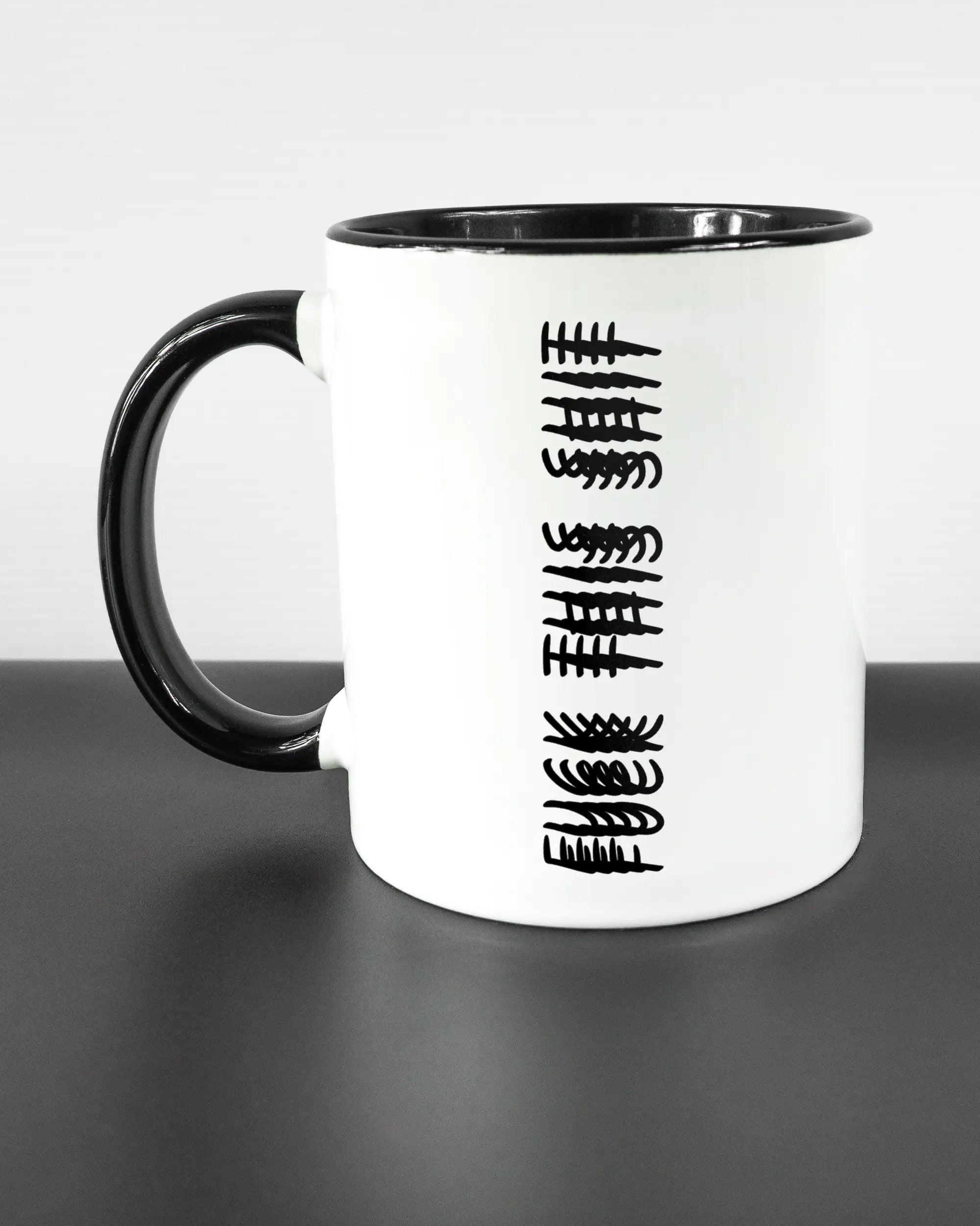 Titelbild, das die linke Seite der beidseitig bedruckten Keramiktasse von Maondo mit dem Design Hidden Message in der Farbe Duotone auf einem Holztisch zeigt