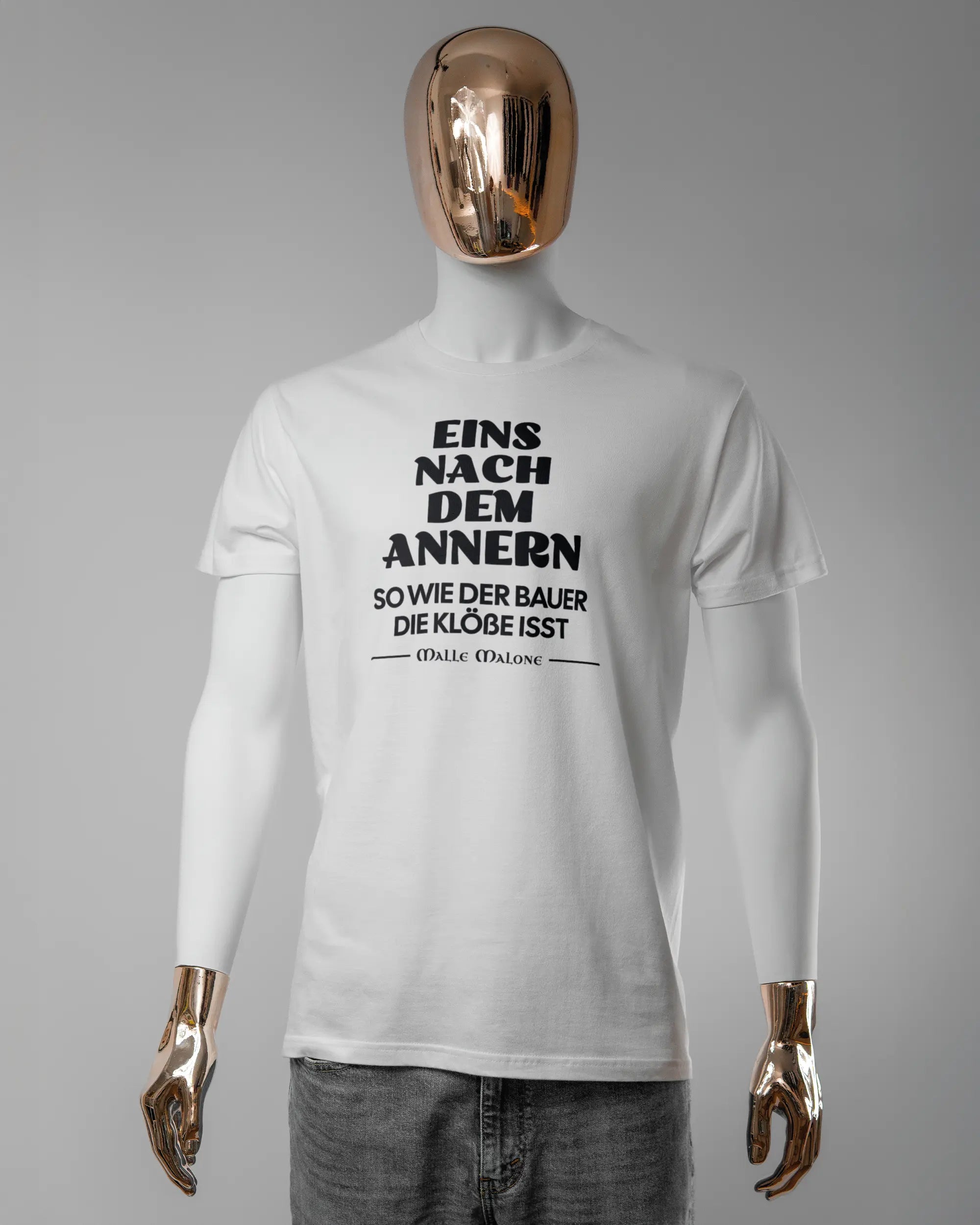 Vorderseite des Basic Unisex T-Shirt Soft von Maondo mit dem Design Eins nach dem Annern in der Farbe White und in der Größe L getragen von einer maskulinen Puppe