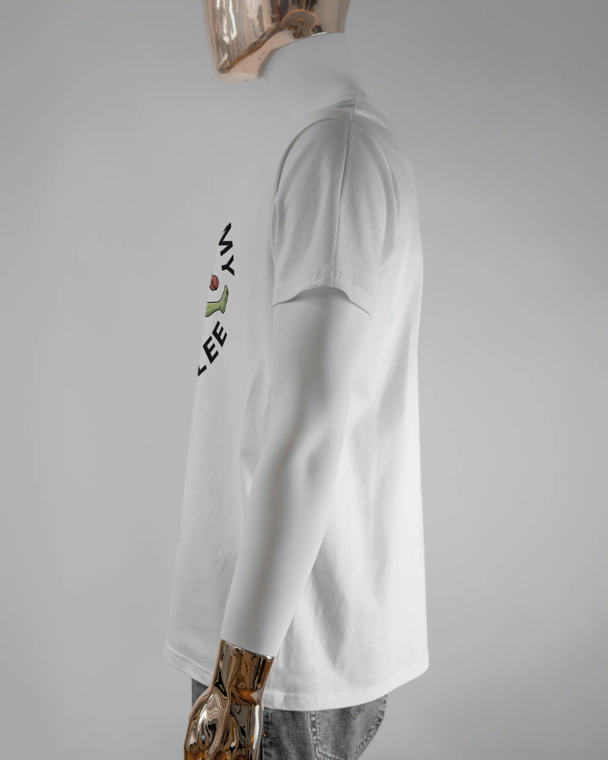 Seitenansicht des Basic Unisex T-Shirt Soft von Maondo mit dem Design Brocco-Lee vorne in der Farbe White und in der Größe L getragen von einer maskulinen Puppe