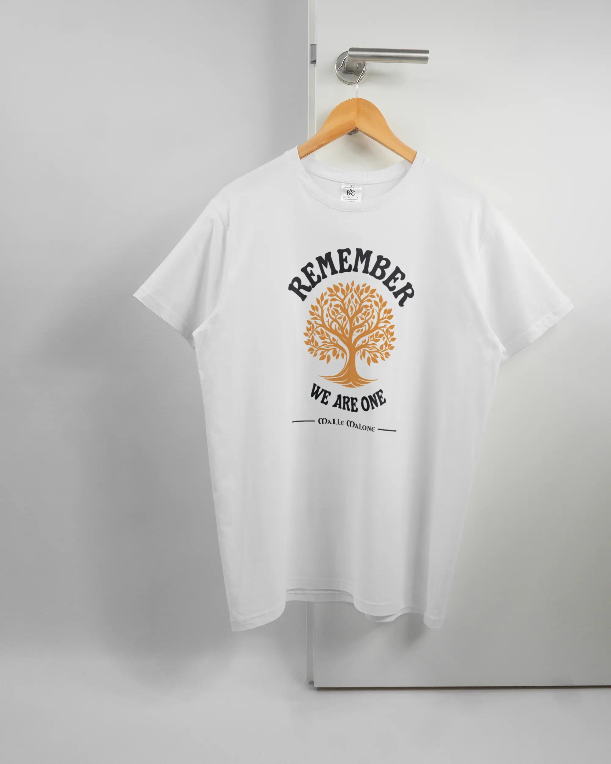 Vorderseite des Basic Unisex T-Shirt Soft von Maondo mit dem Design We are one in der Farbe White und in der Größe L auf einem Bügel an der Türklinke aufgehängt