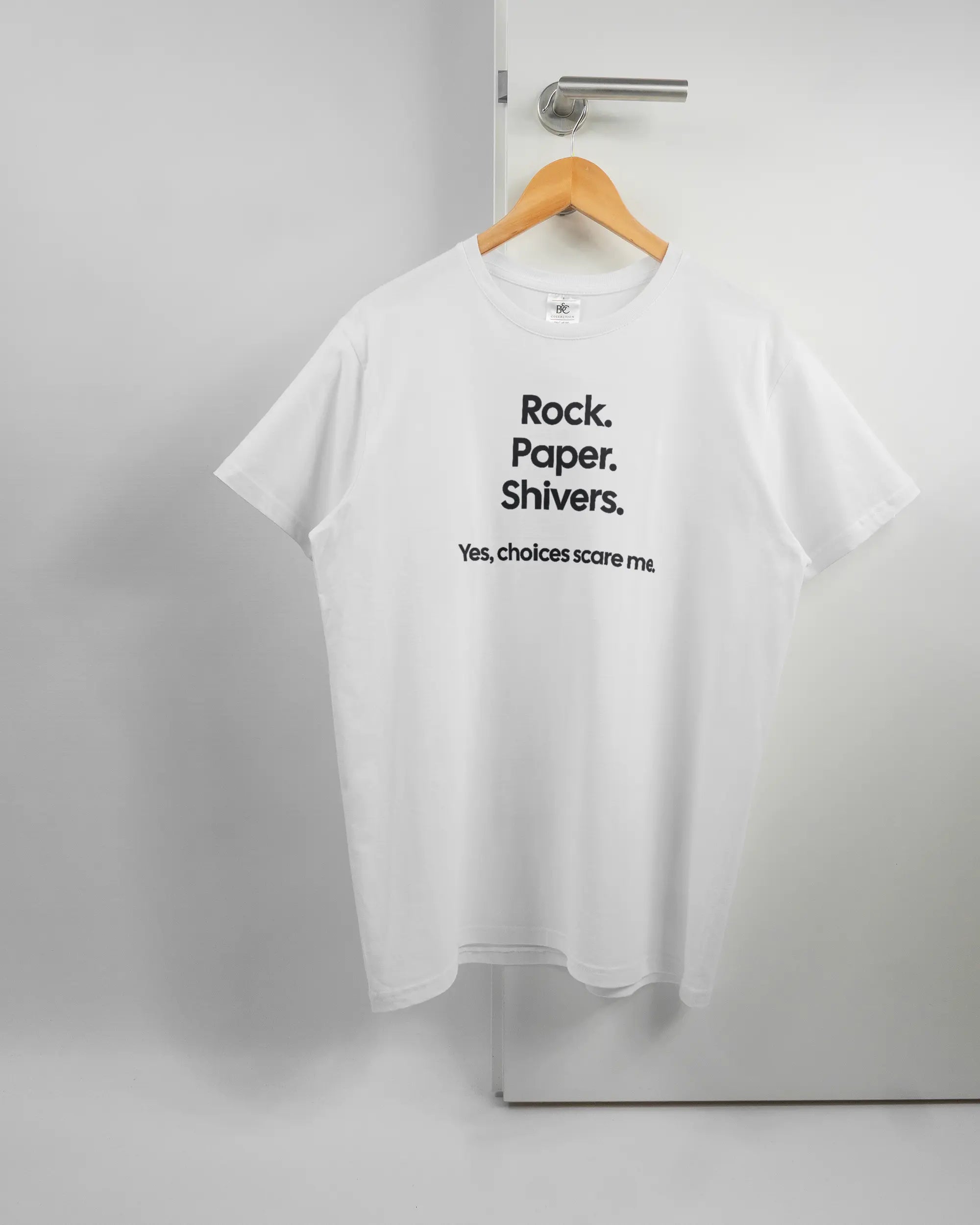 Vorderseite des Basic Unisex T-Shirt Soft von Maondo mit dem Design Rock Paper Shivers in der Farbe White und in der Größe L auf einem Bügel an der Türklinke aufgehängt