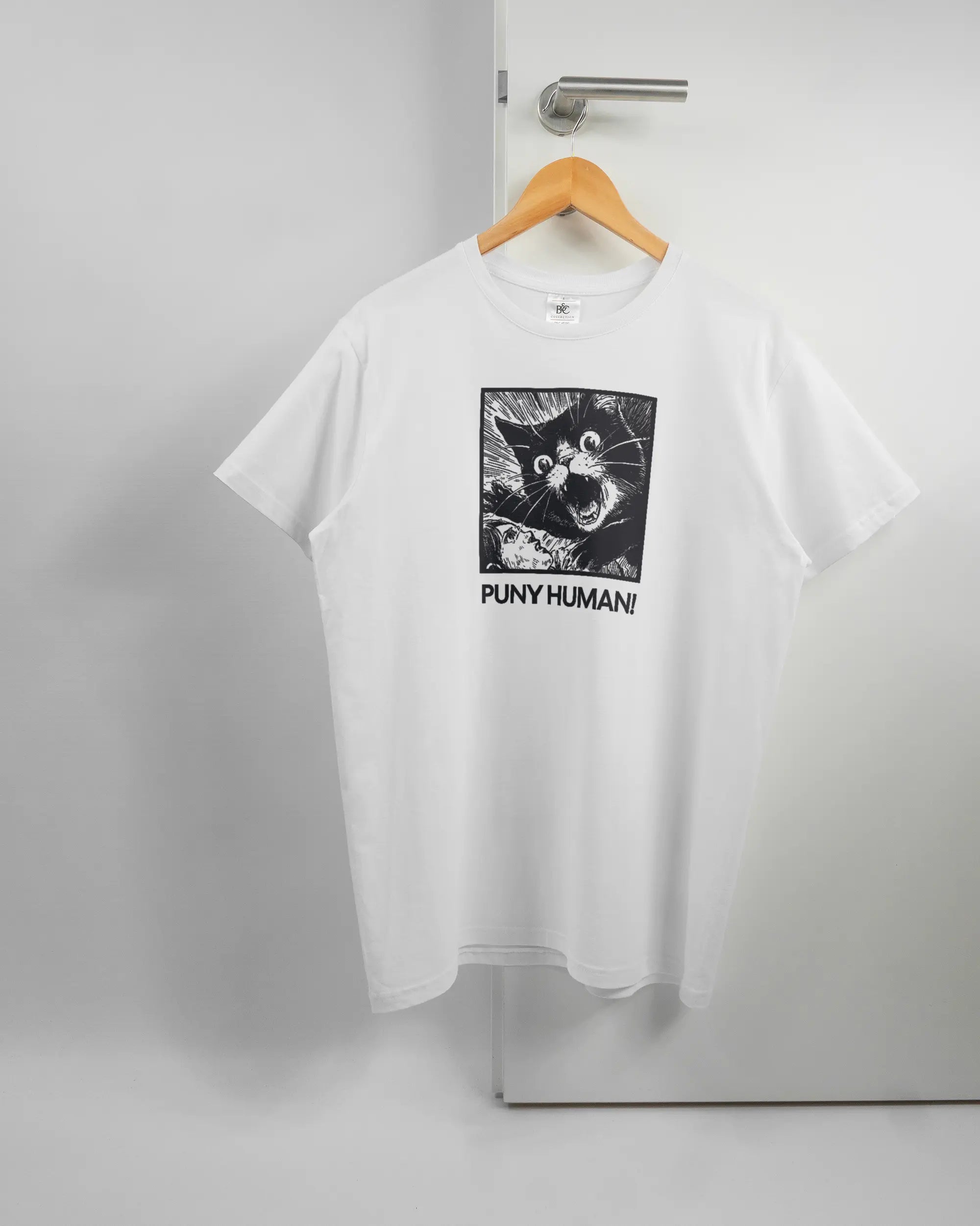 Vorderseite des Basic Unisex T-Shirt Soft von Maondo mit dem Design Puny Human in der Farbe White und in der Größe L auf einem Bügel an der Türklinke aufgehängt