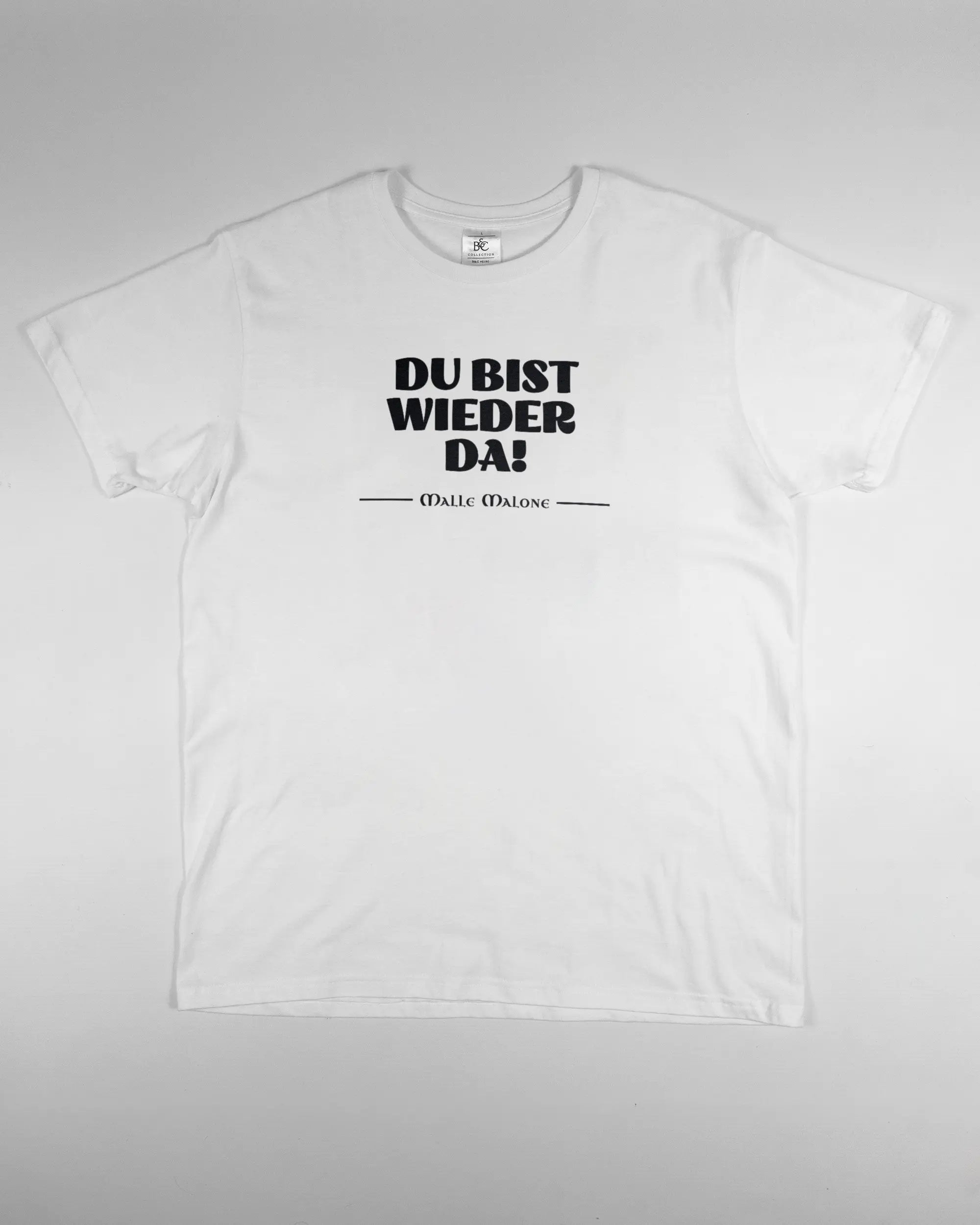 Vorderseite des Basic Unisex T-Shirt Soft von Maondo mit dem Design Wieder da in der Farbe White und in der Größe L flach auf den Boden gelegt