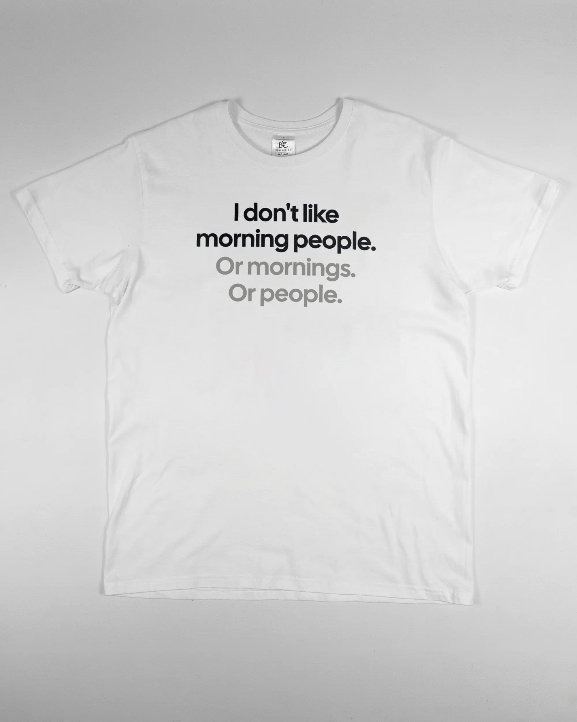 Vorderseite des Basic Unisex T-Shirt Soft von Maondo mit dem Design Morning Person in der Farbe White und in der Größe L flach auf den Boden gelegt