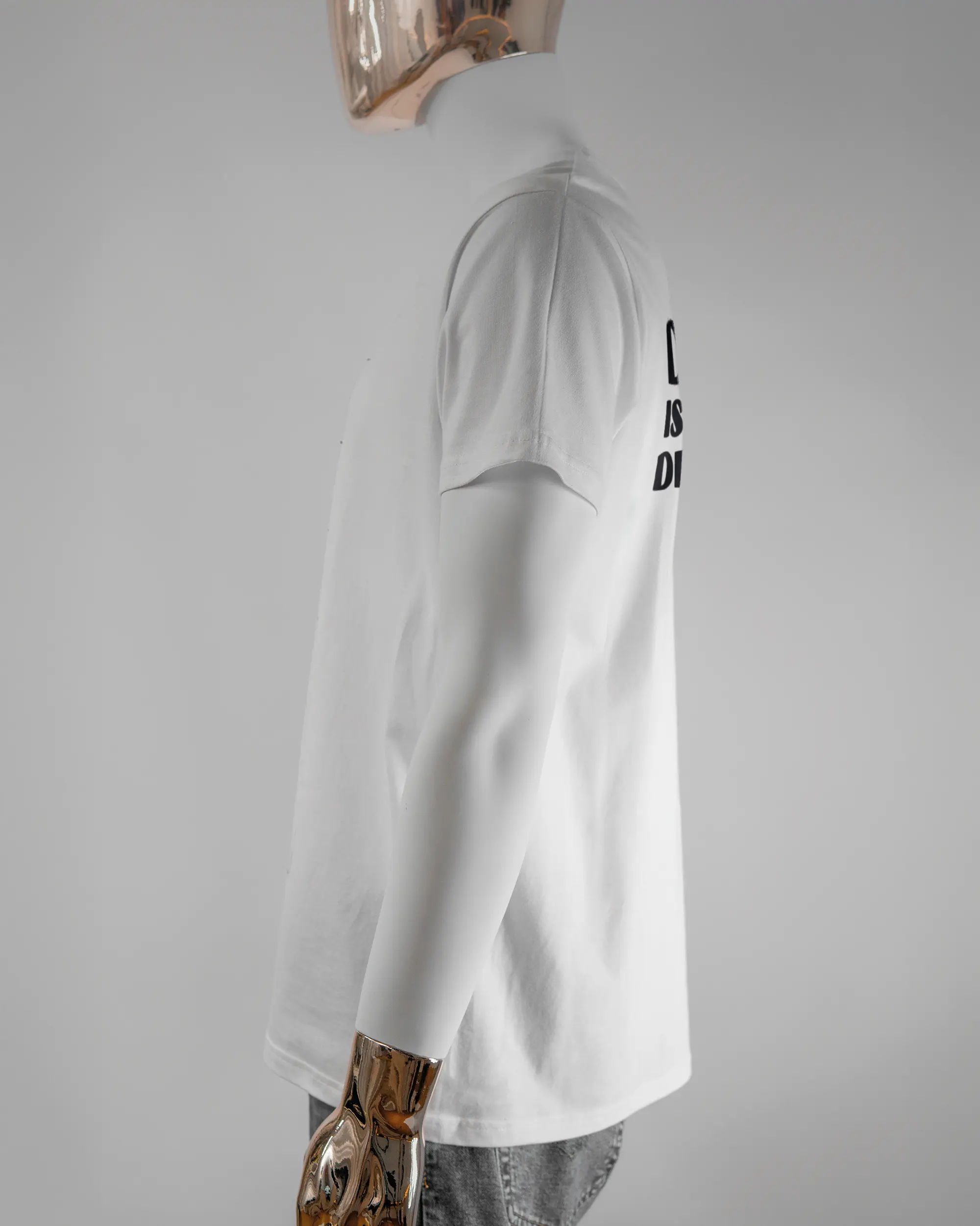 Seitenansicht des Basic Unisex T-Shirt Soft von Maondo mit dem Design Keine Eile hinten in der Farbe White und in der Größe L getragen von einer maskulinen Puppe