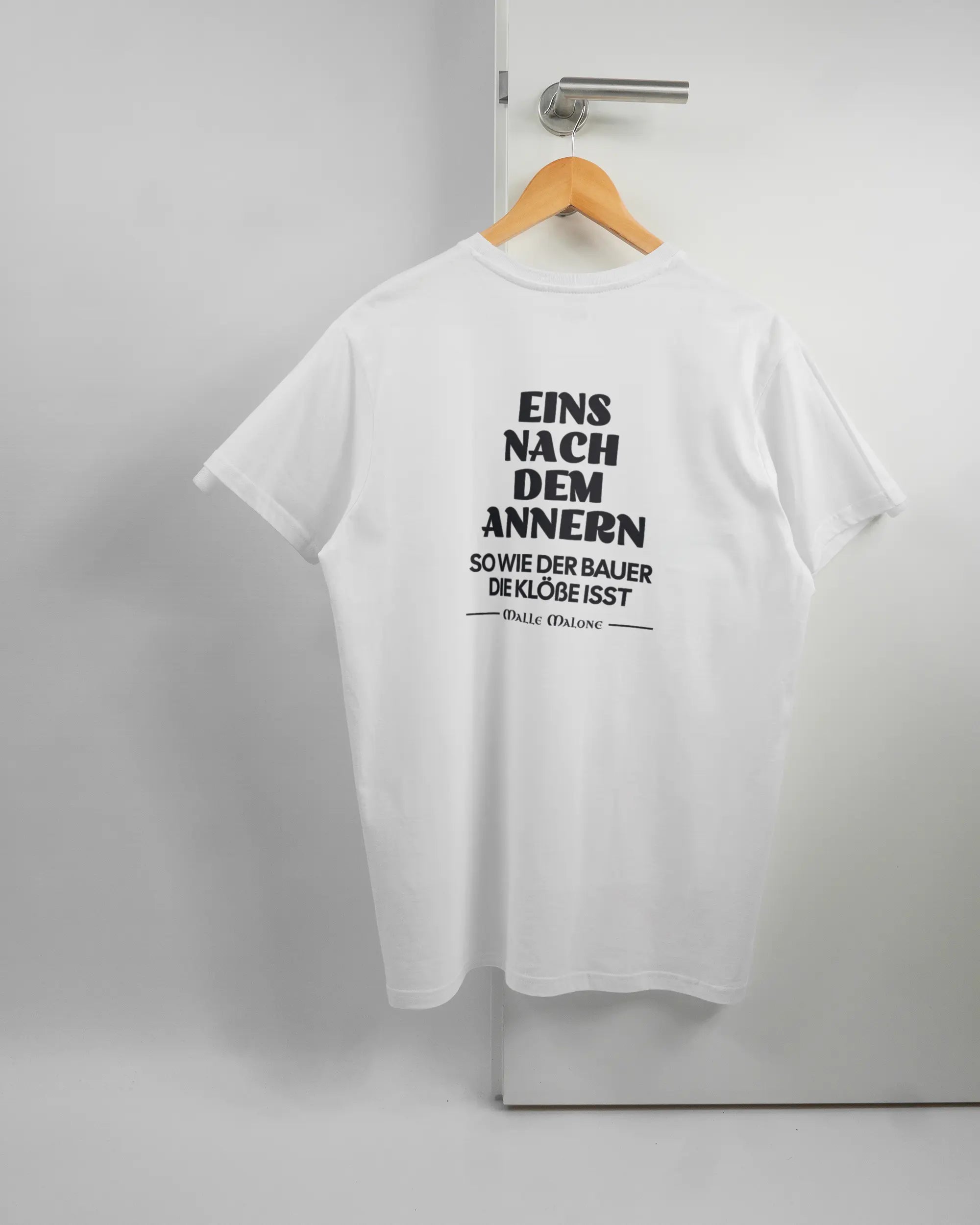 Rückseite des Basic Unisex T-Shirt Soft von Maondo mit dem Design Eins nach dem Annern in der Farbe White und in der Größe L auf einem Bügel an der Türklinke aufgehängt