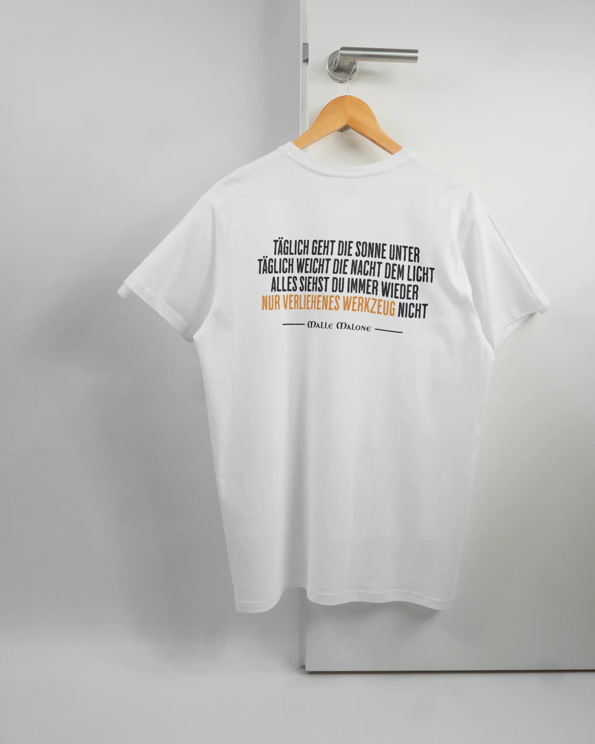 Rückseite des Basic Unisex T-Shirt Soft von Maondo mit dem Design Wegzeug in der Farbe White und in der Größe L auf einem Bügel an der Türklinke aufgehängt