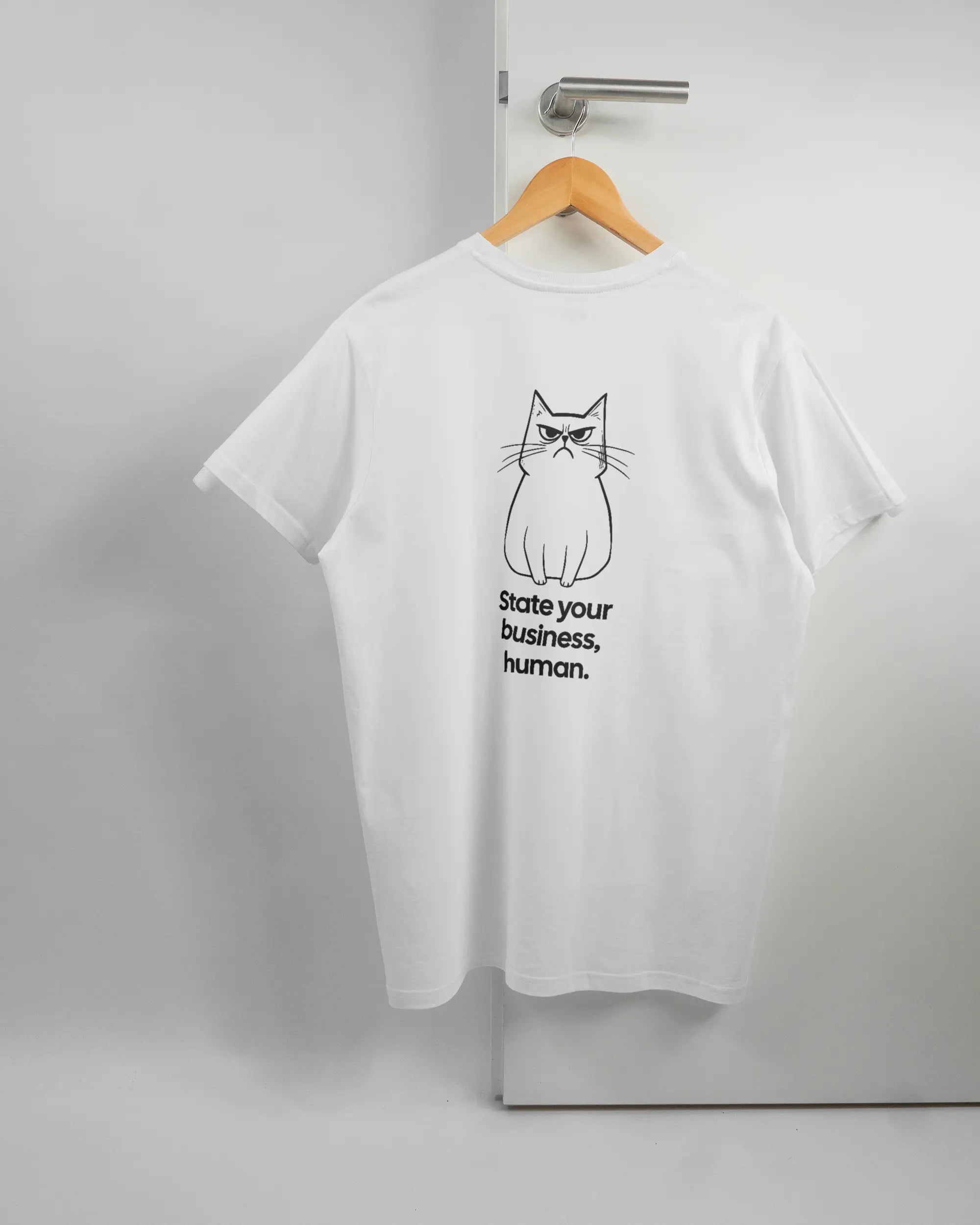 Rückseite des Basic Unisex T-Shirt Soft von Maondo mit dem Design Grumpy Purr in der Farbe White und in der Größe L auf einem Bügel an der Türklinke aufgehängt