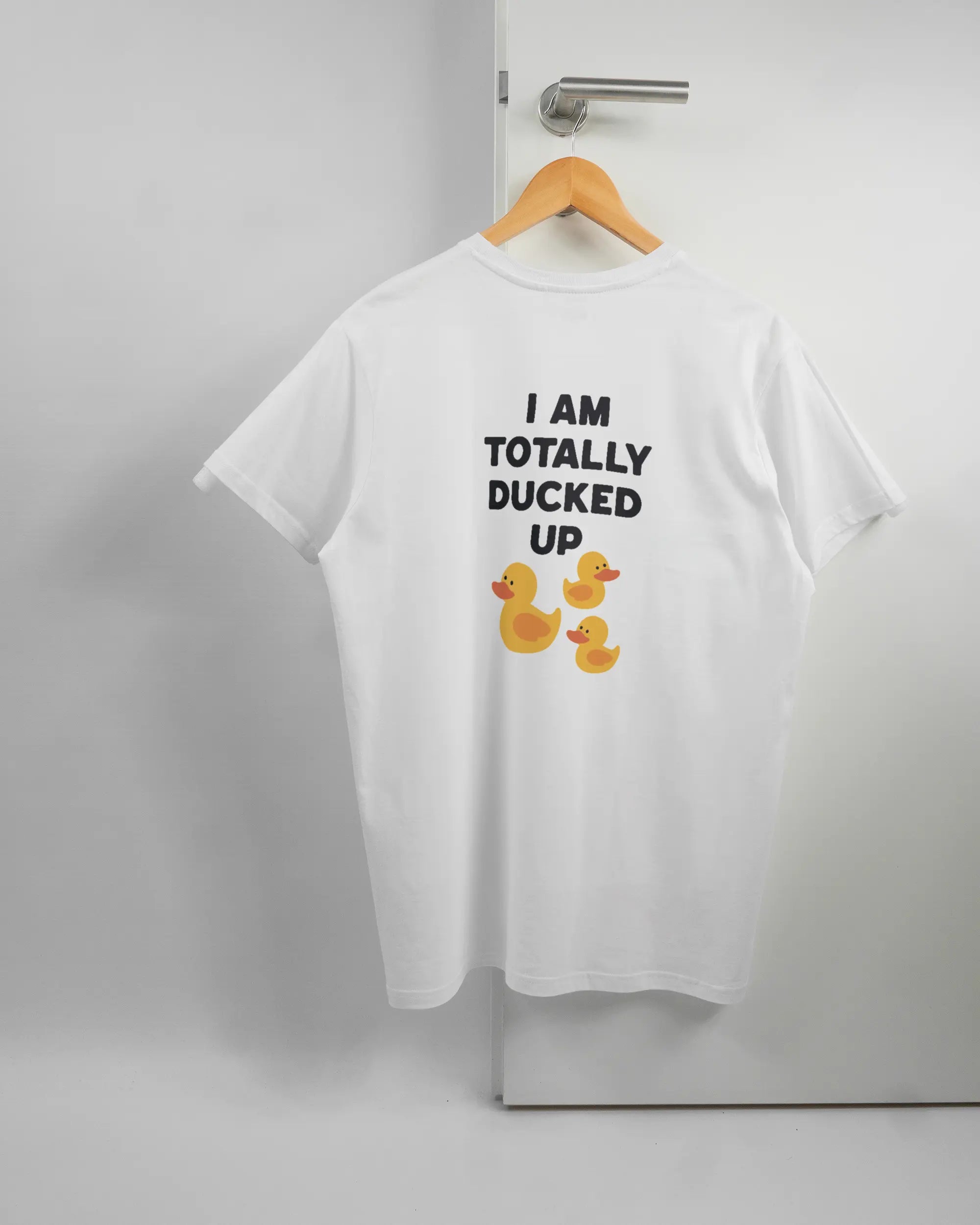 Rückseite des Basic Unisex T-Shirt Soft von Maondo mit dem Design Ducked Up in der Farbe White und in der Größe L auf einem Bügel an der Türklinke aufgehängt