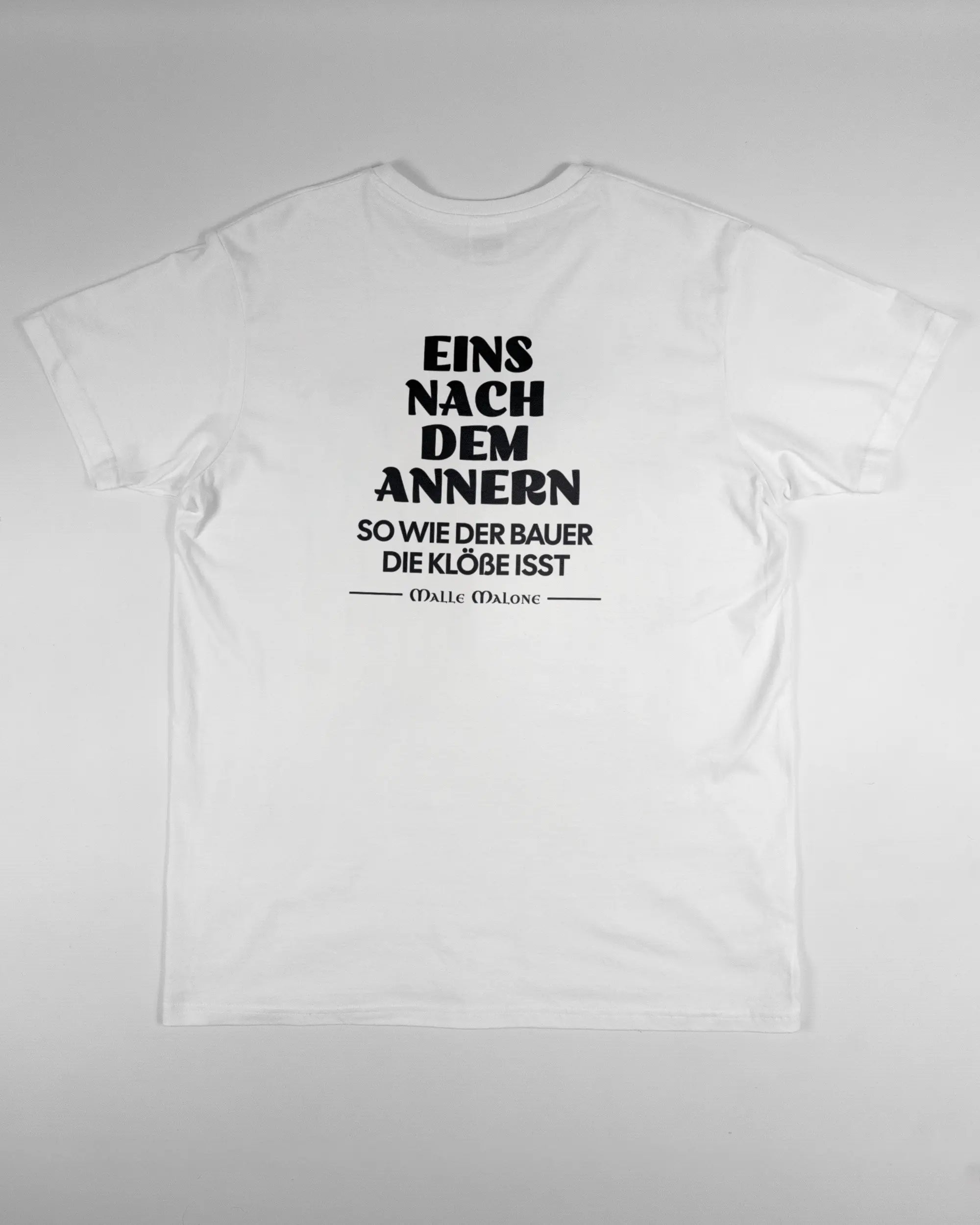 Rückseite des Basic Unisex T-Shirt Soft von Maondo mit dem Design Eins nach dem Annern in der Farbe White und in der Größe L flach auf den Boden gelegt