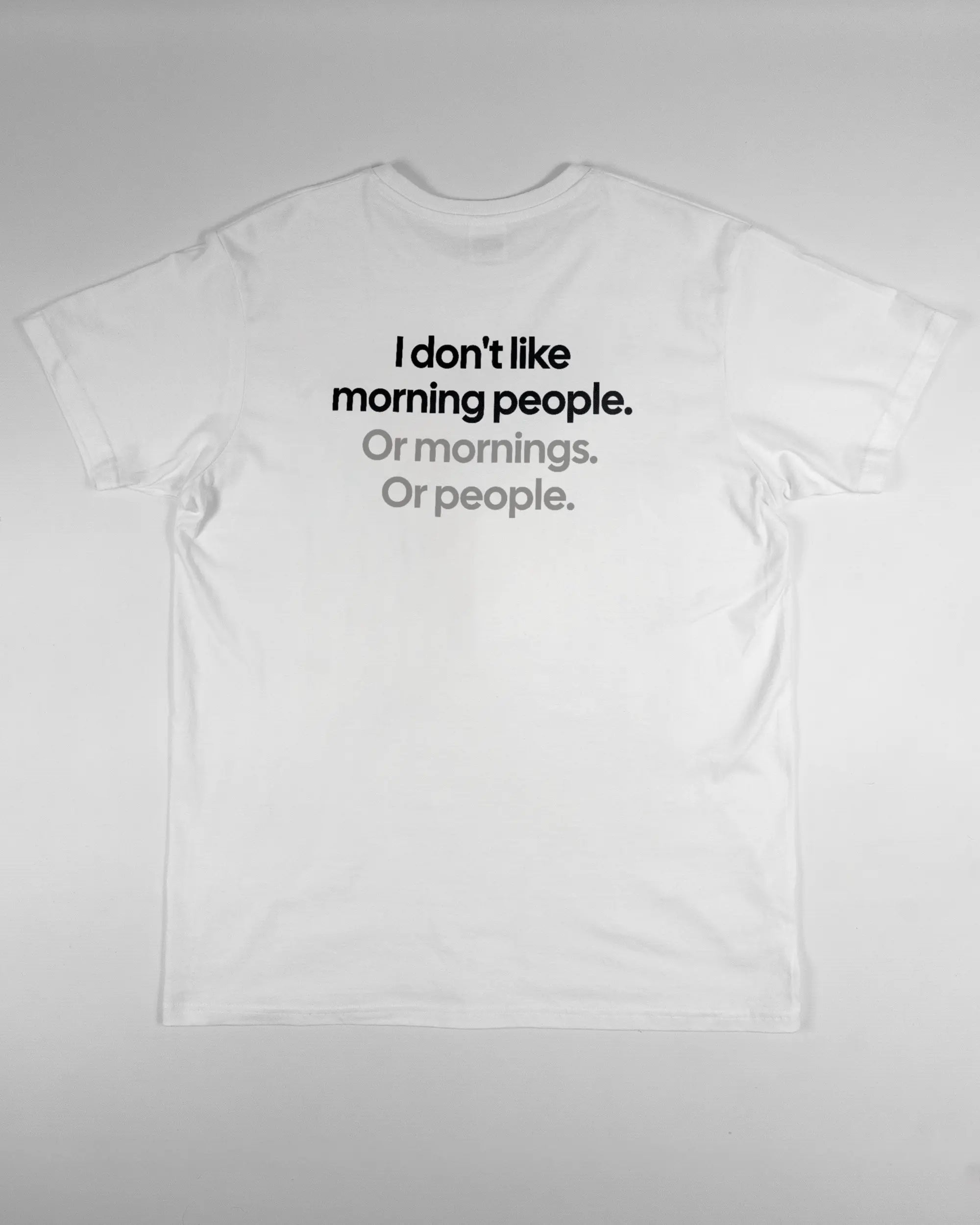 Rückseite des Basic Unisex T-Shirt Soft von Maondo mit dem Design Morning Person in der Farbe White und in der Größe L flach auf den Boden gelegt