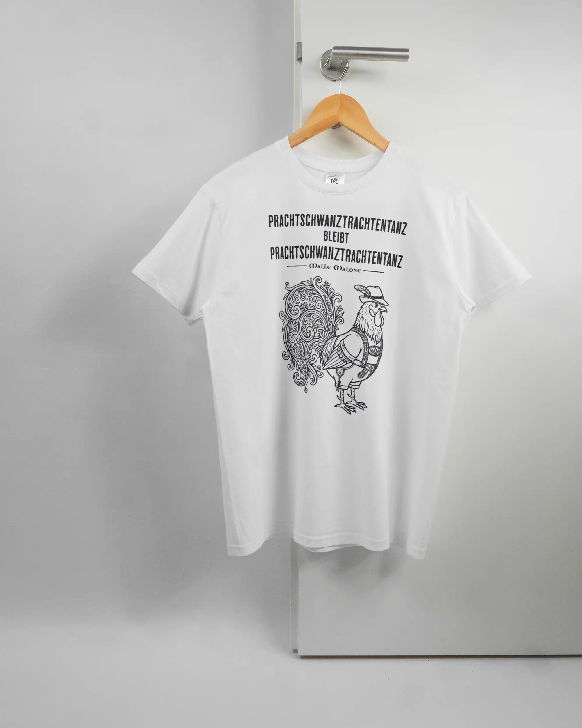 Vorderseite des Basic Unisex T-Shirt Soft von Maondo mit dem Design Trachtentanz in der Farbe White und in der Größe S auf einem Bügel an der Türklinke aufgehängt