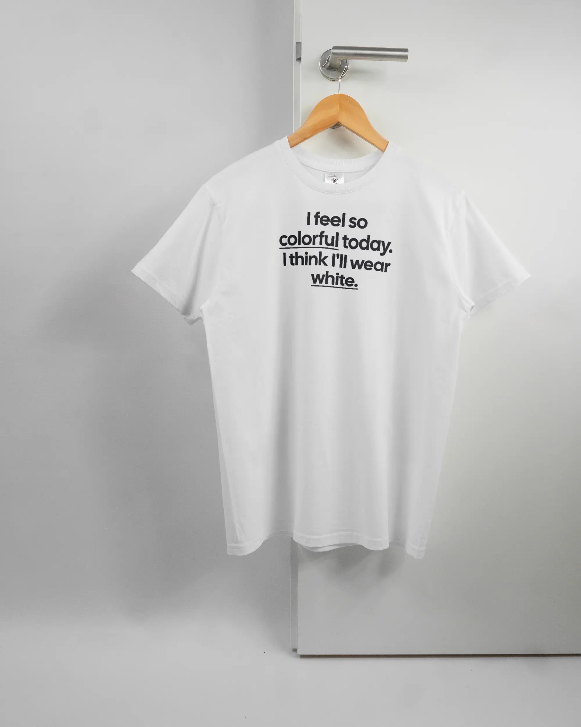 Vorderseite des Basic Unisex T-Shirt Slim von Maondo mit dem Design Colorful Day in der Farbe White und in der Größe S auf einem Bügel an der Türklinke aufgehängt