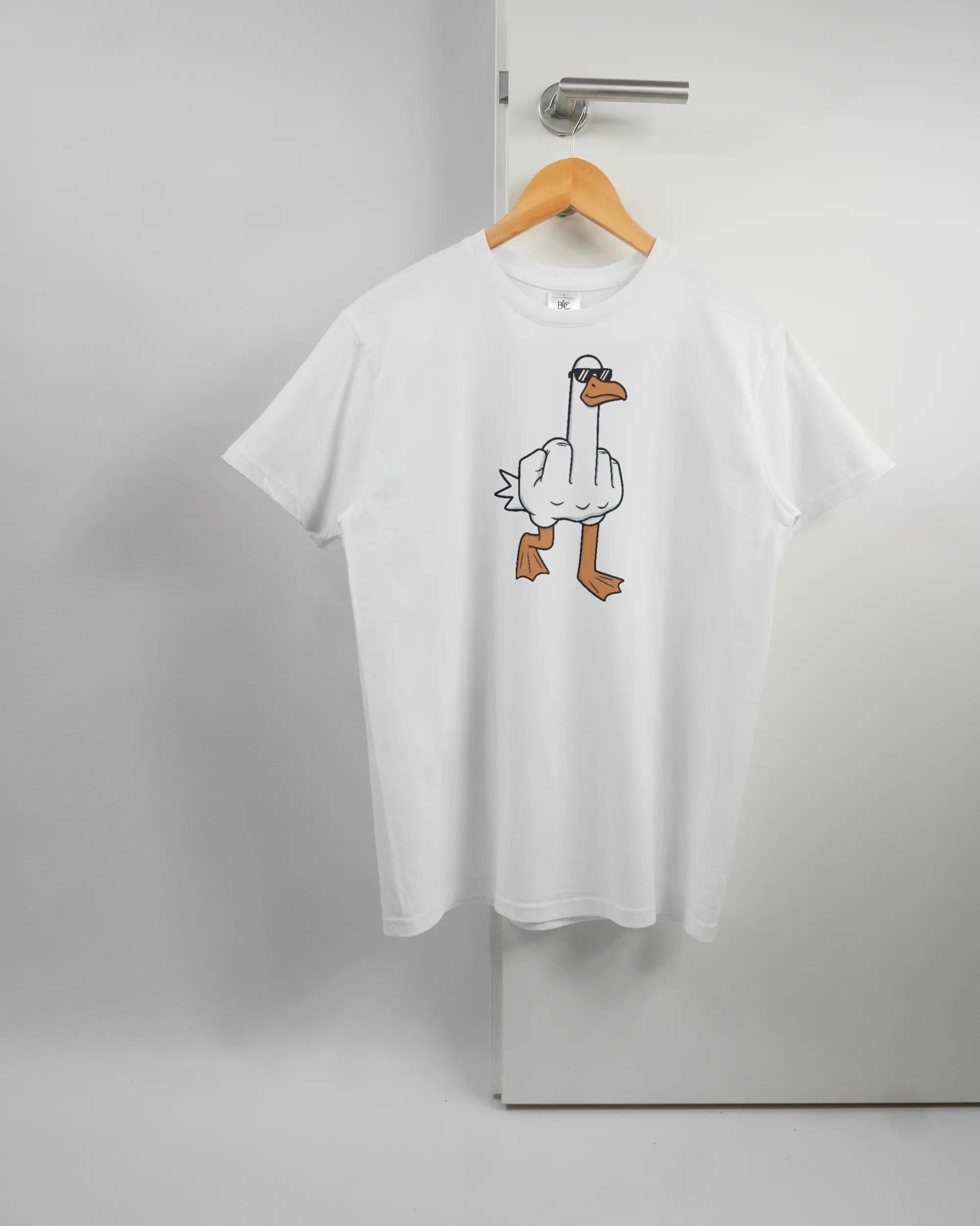 Vorderseite des Basic Unisex T-Shirt Soft von Maondo mit dem Design I give a duck in der Farbe White und in der Größe S auf einem Bügel an der Türklinke aufgehängt