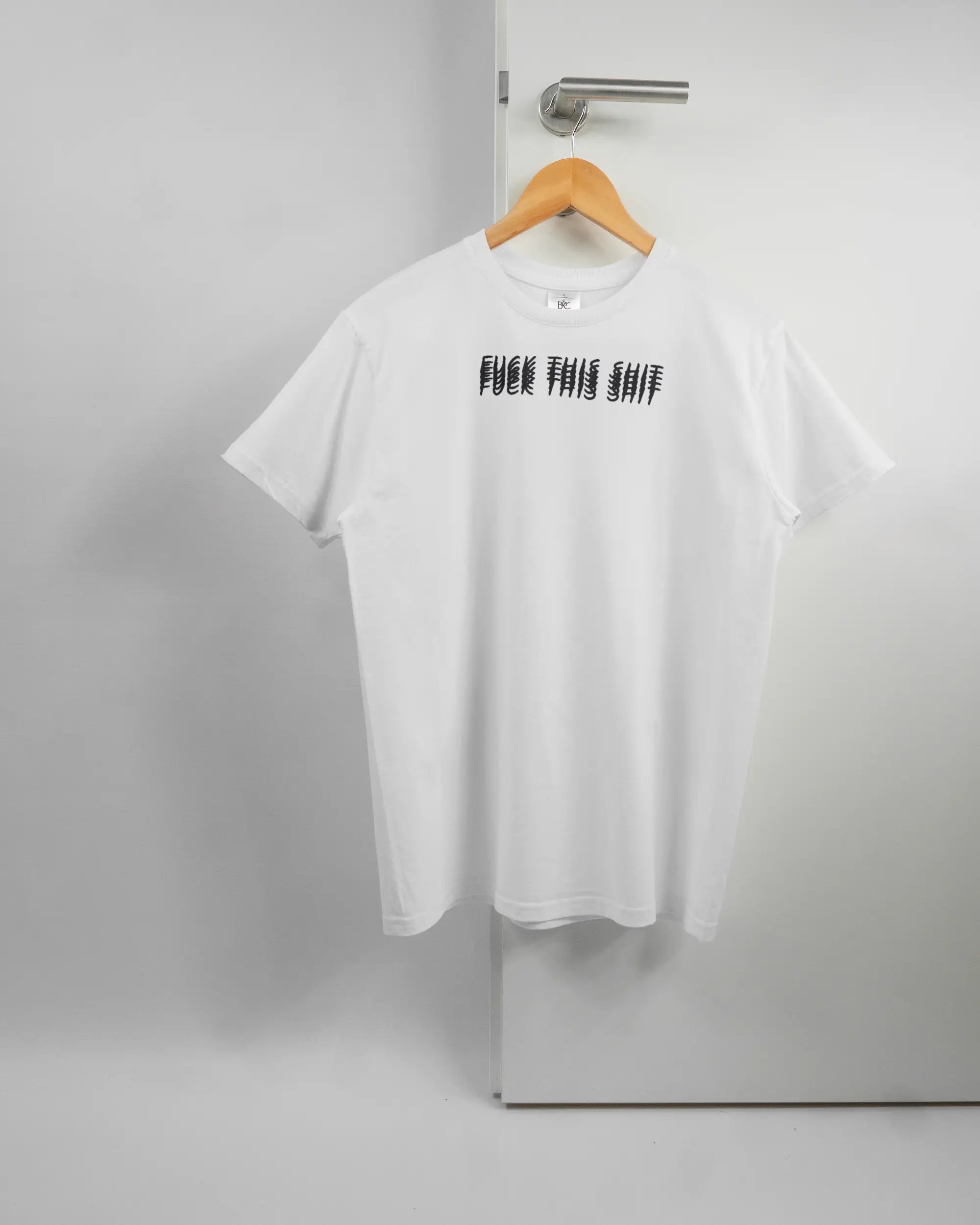 Vorderseite des Basic Unisex T-Shirt Soft von Maondo mit dem Design Hidden Message in der Farbe White und in der Größe S auf einem Bügel an der Türklinke aufgehängt
