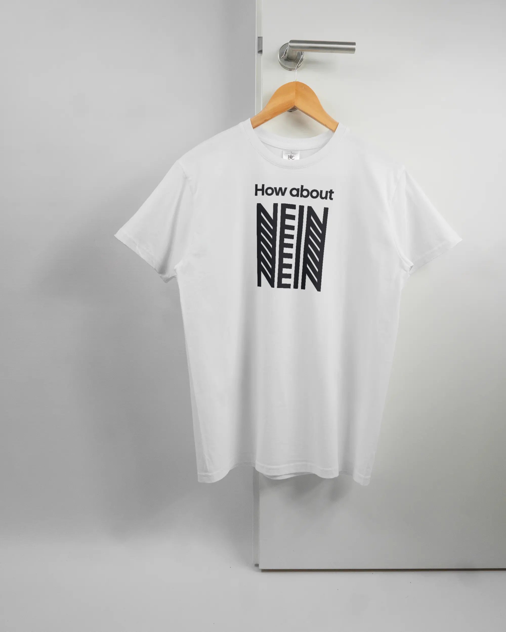 Vorderseite des Basic Unisex T-Shirt Soft von Maondo mit dem Design How about nein in der Farbe White und in der Größe S auf einem Bügel an der Türklinke aufgehängt