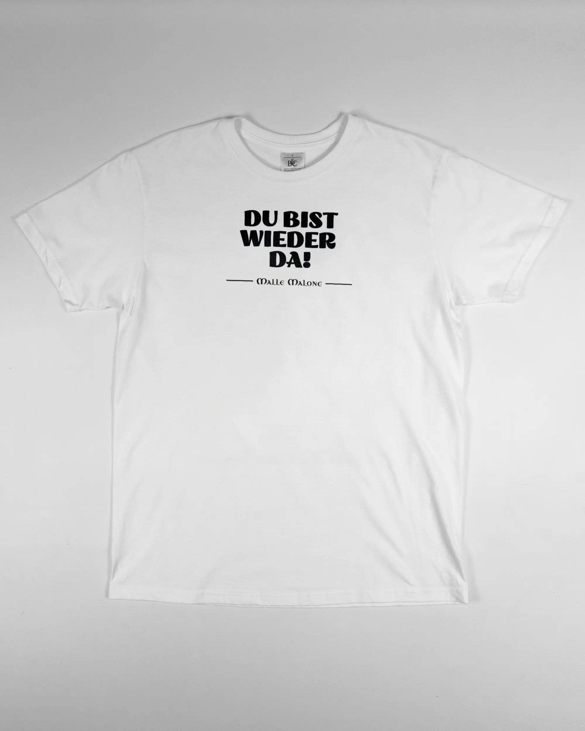 Vorderseite des Basic Unisex T-Shirt Soft von Maondo mit dem Design Wieder da in der Farbe White und in der Größe S flach auf den Boden gelegt