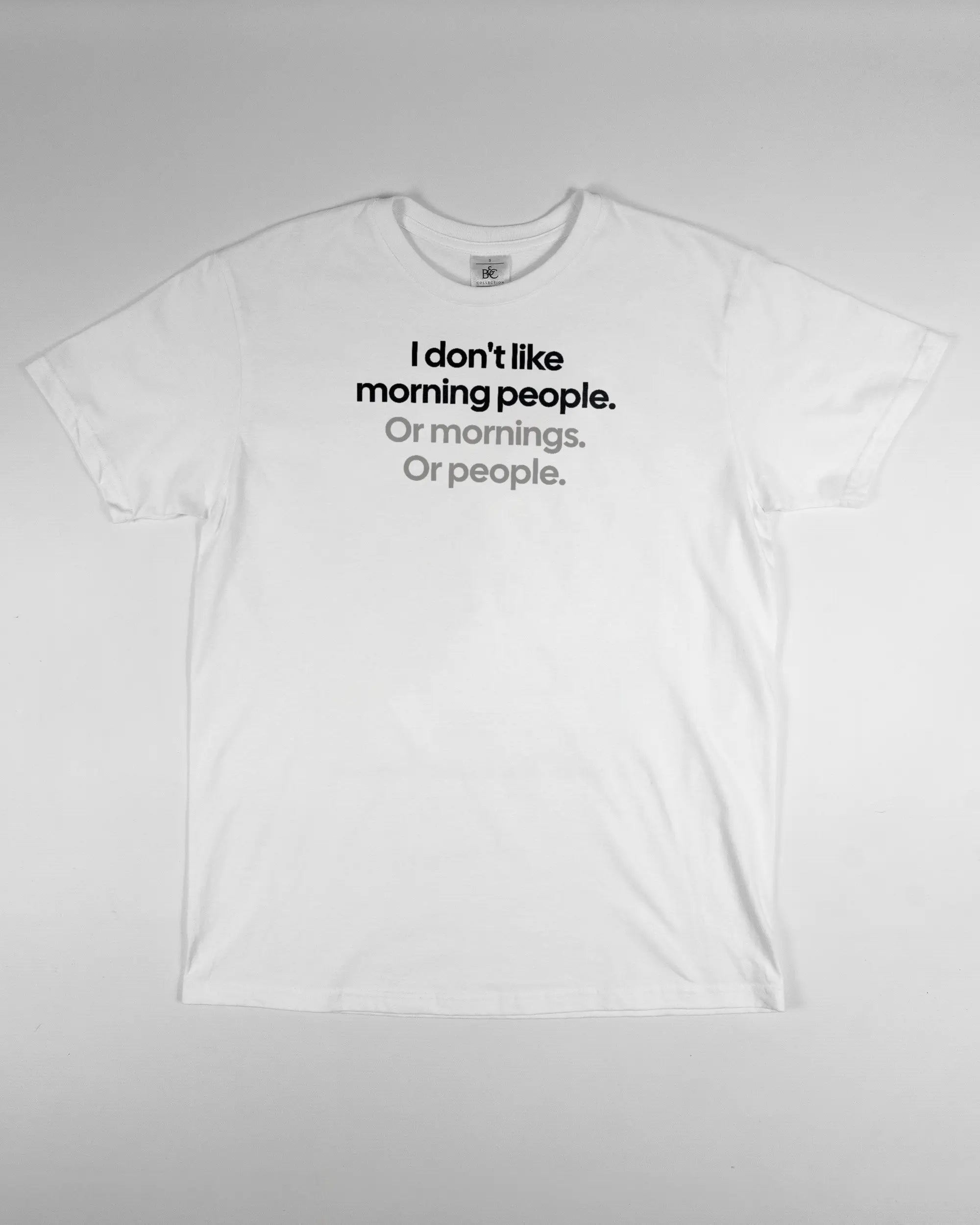 Vorderseite des Basic Unisex T-Shirt Soft von Maondo mit dem Design Morning Person in der Farbe White und in der Größe S flach auf den Boden gelegt