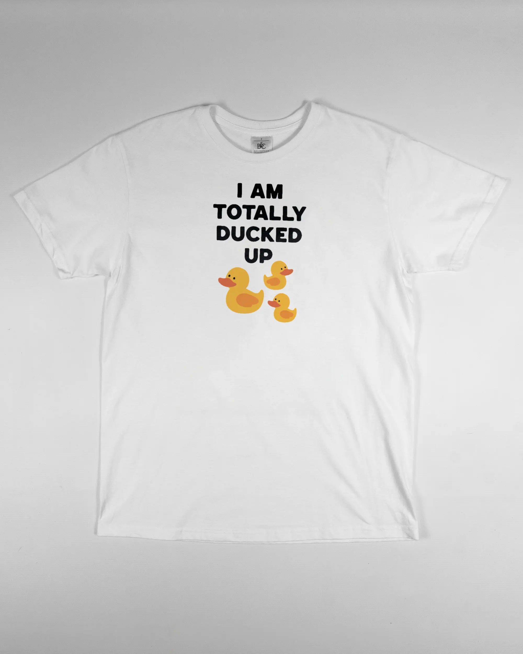 Vorderseite des Basic Unisex T-Shirt Soft von Maondo mit dem Design Ducked Up in der Farbe White und in der Größe S flach auf den Boden gelegt