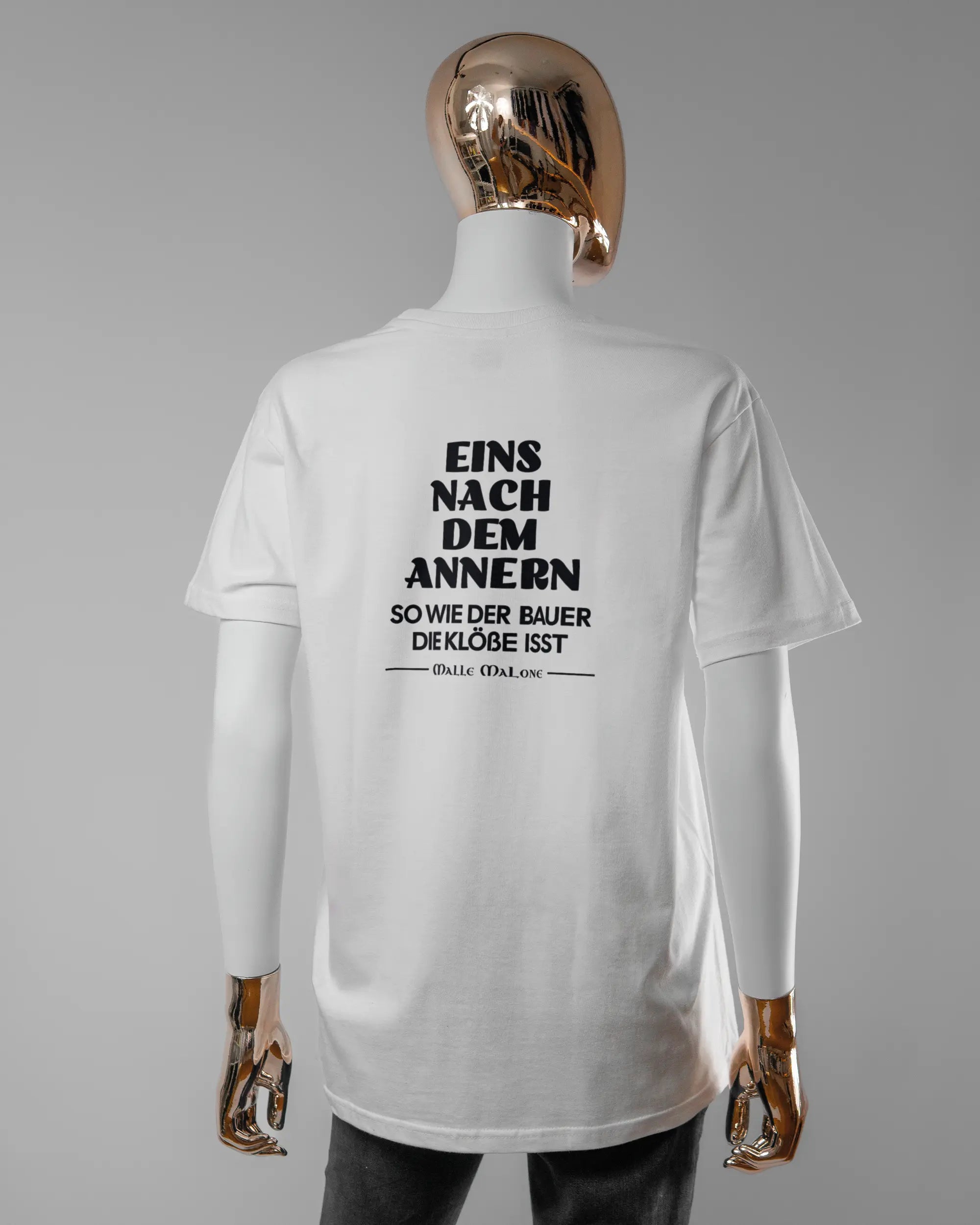 Rückseite des Basic Unisex T-Shirt Soft von Maondo mit dem Design Eins nach dem Annern in der Farbe White und in der Größe S getragen von einer femininen Puppe