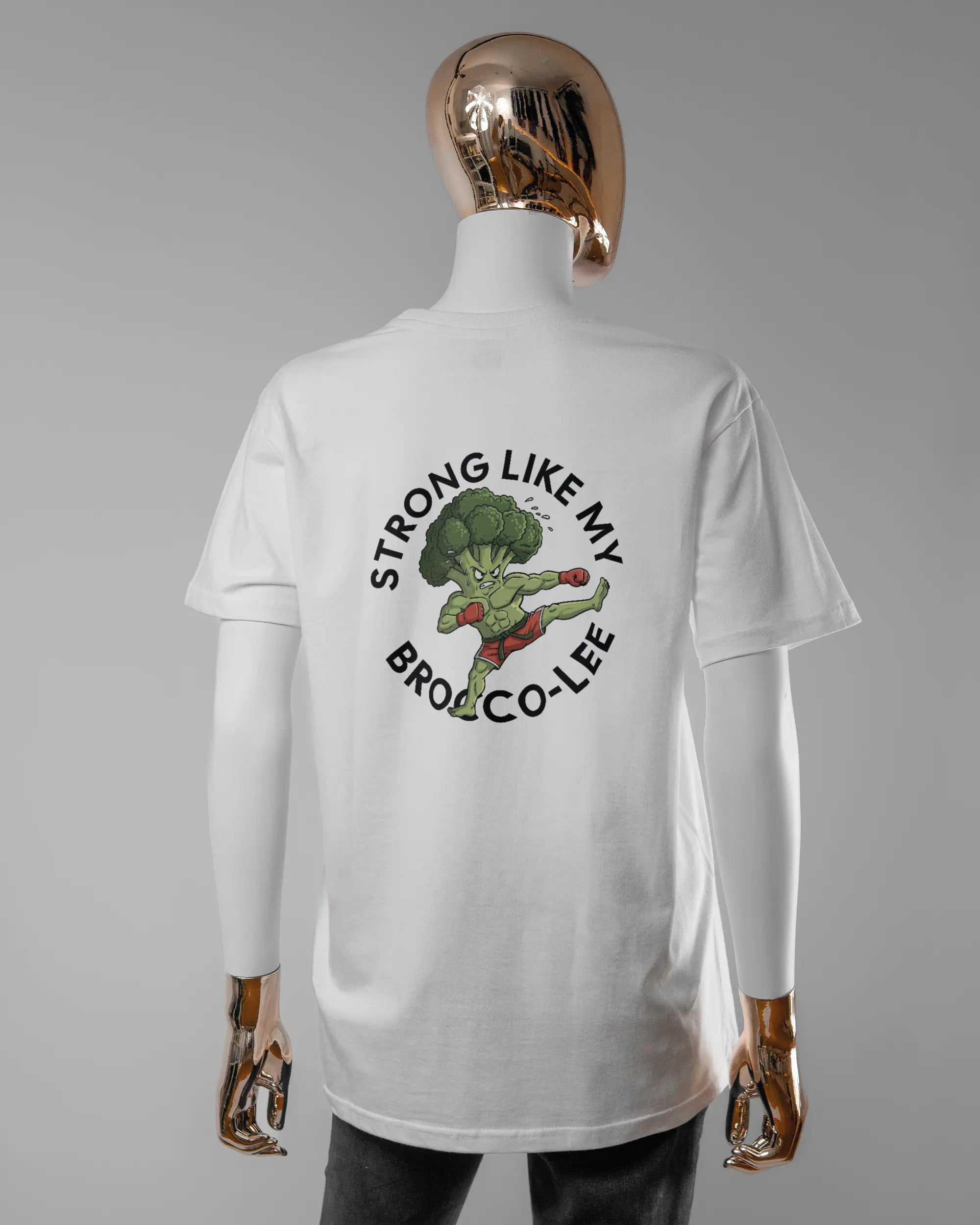Rückseite des Basic Unisex T-Shirt Soft von Maondo mit dem Design Brocco-Lee in der Farbe White und in der Größe S getragen von einer femininen Puppe