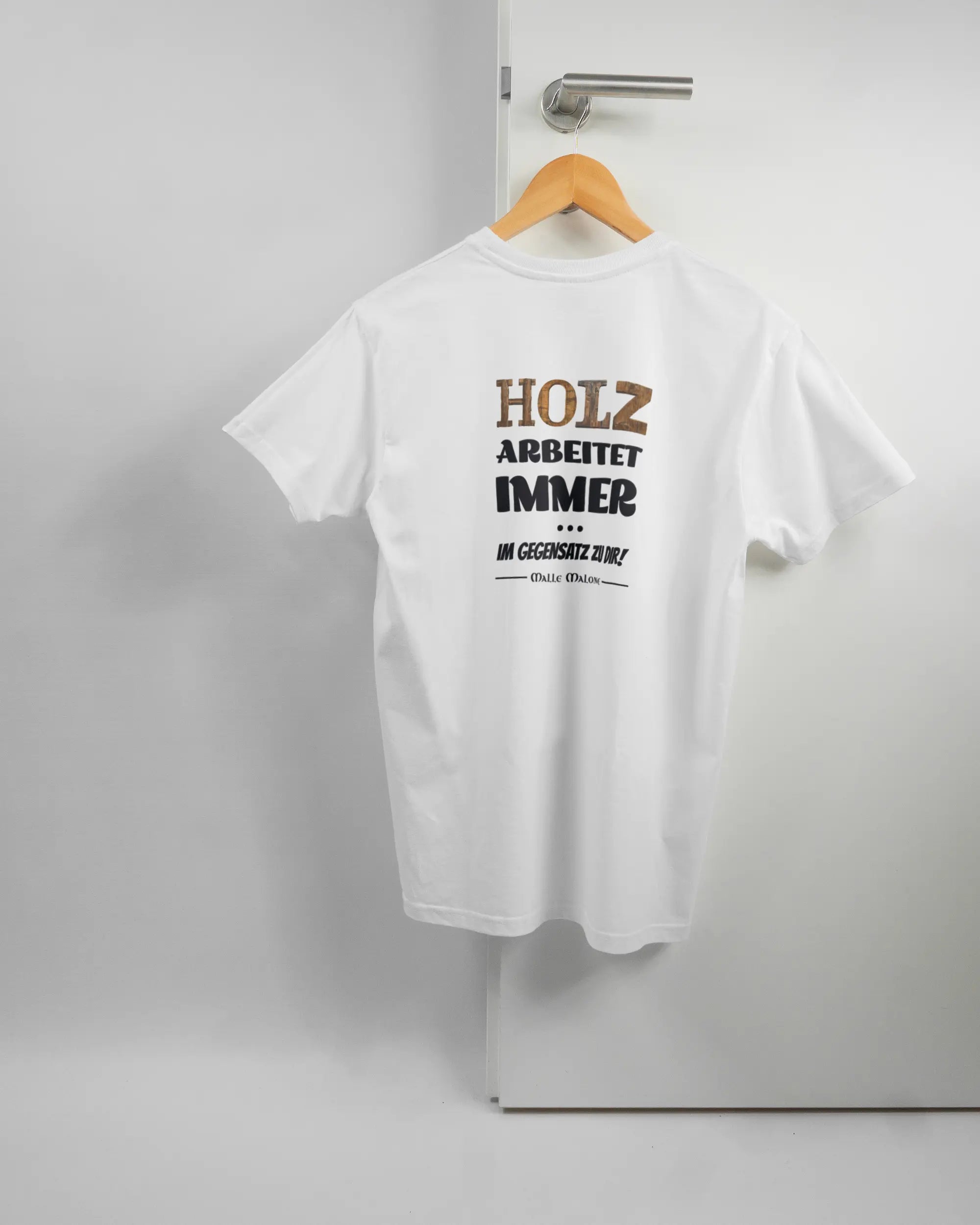 Rückseite des Basic Unisex T-Shirt Soft von Maondo mit dem Design Holzarbeit in der Farbe White und in der Größe S auf einem Bügel an der Türklinke aufgehängt