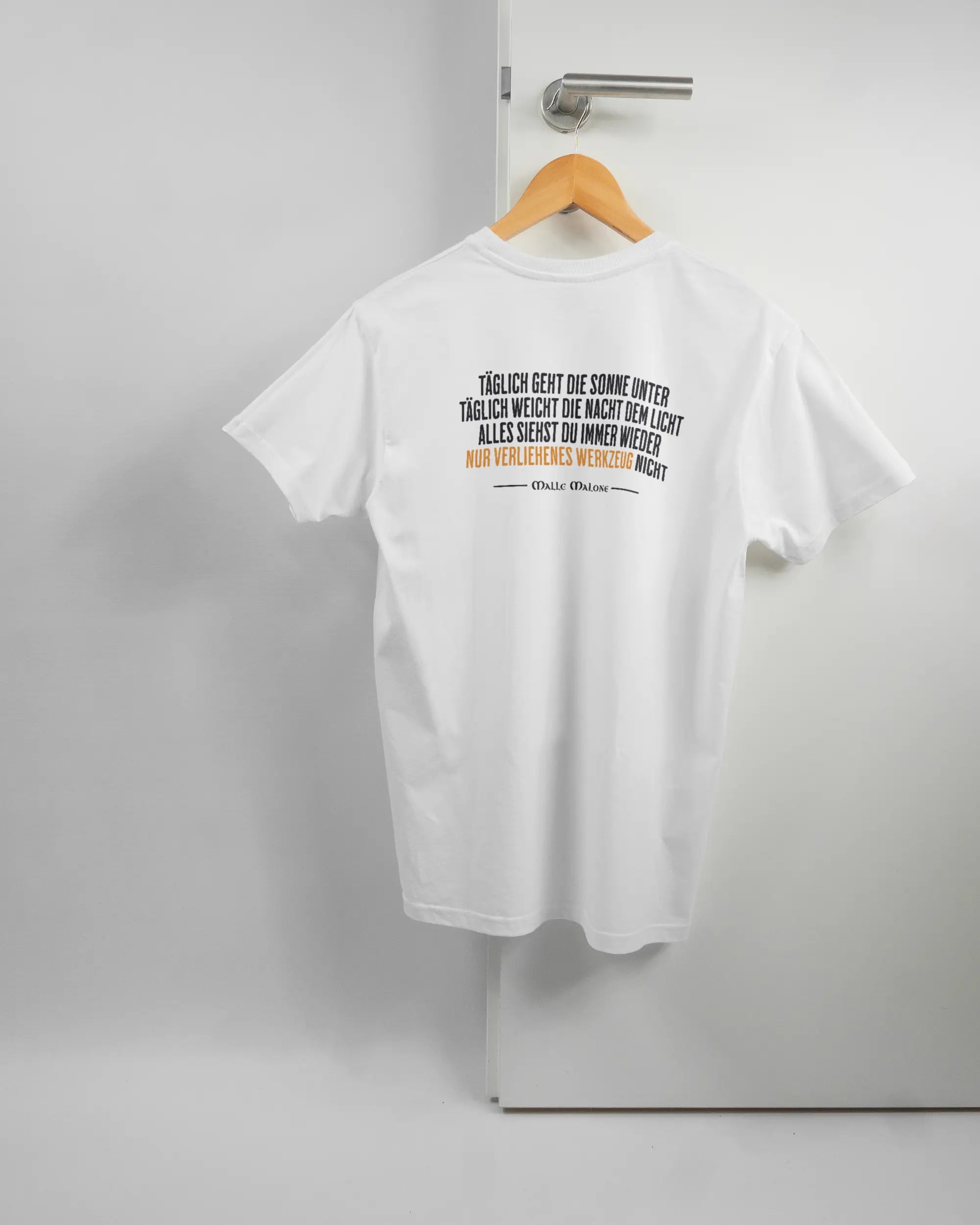 Rückseite des Basic Unisex T-Shirt Soft von Maondo mit dem Design Wegzeug in der Farbe White und in der Größe S auf einem Bügel an der Türklinke aufgehängt