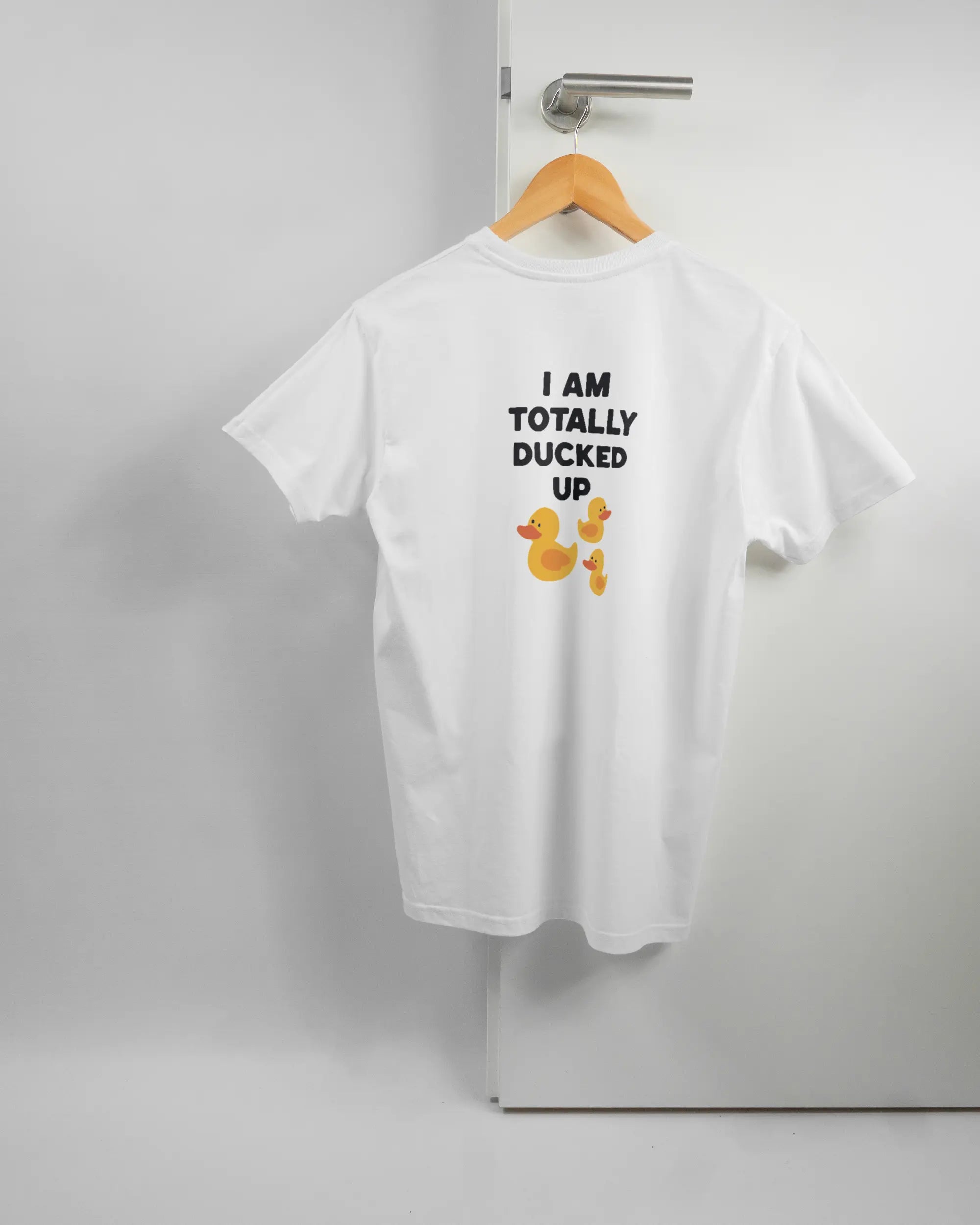 Rückseite des Basic Unisex T-Shirt Soft von Maondo mit dem Design Ducked Up in der Farbe White und in der Größe S auf einem Bügel an der Türklinke aufgehängt
