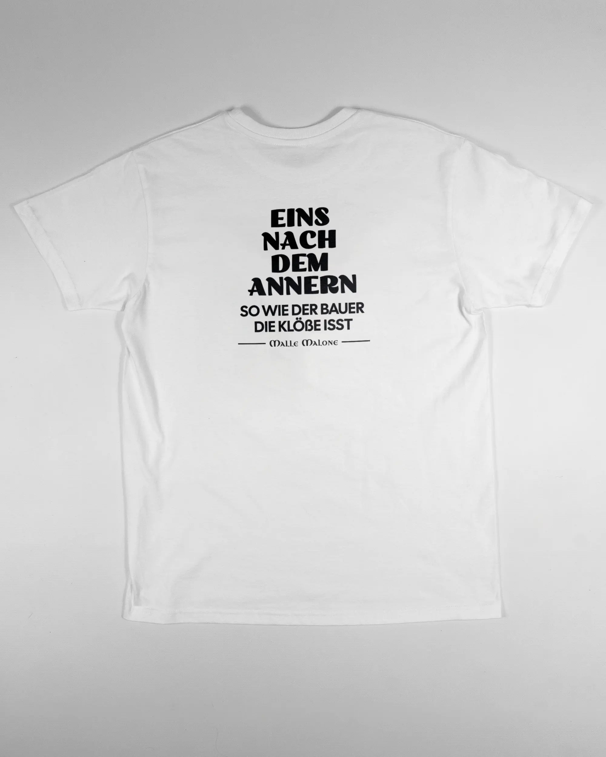 Rückseite des Basic Unisex T-Shirt Soft von Maondo mit dem Design Eins nach dem Annern in der Farbe White und in der Größe S flach auf den Boden gelegt