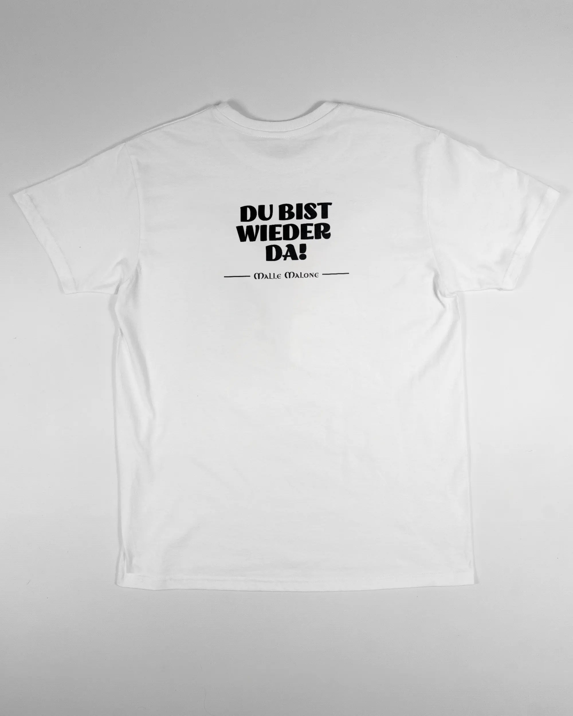Rückseite des Basic Unisex T-Shirt Soft von Maondo mit dem Design Wieder da in der Farbe White und in der Größe S flach auf den Boden gelegt