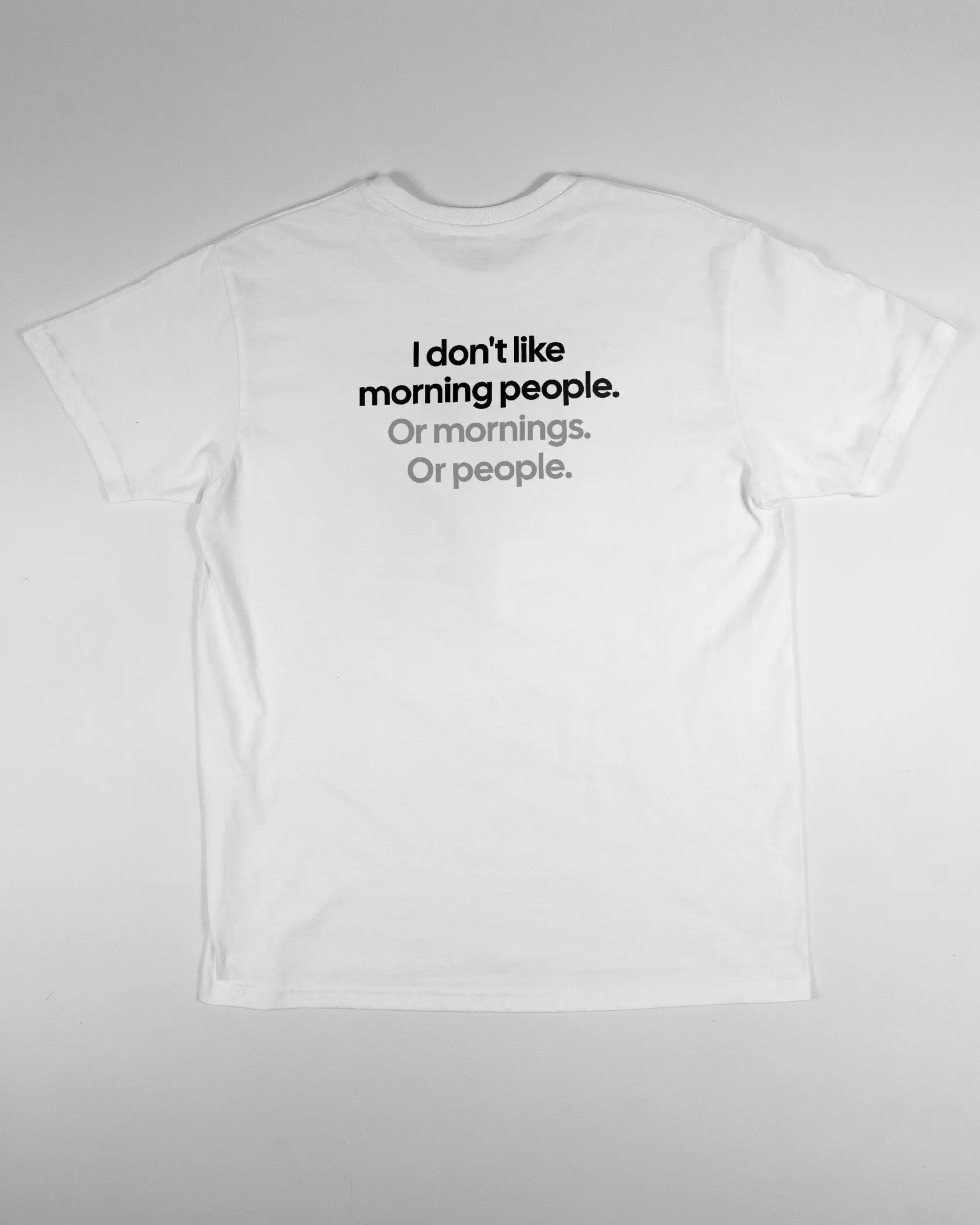 Rückseite des Basic Unisex T-Shirt Soft von Maondo mit dem Design Morning Person in der Farbe White und in der Größe S flach auf den Boden gelegt