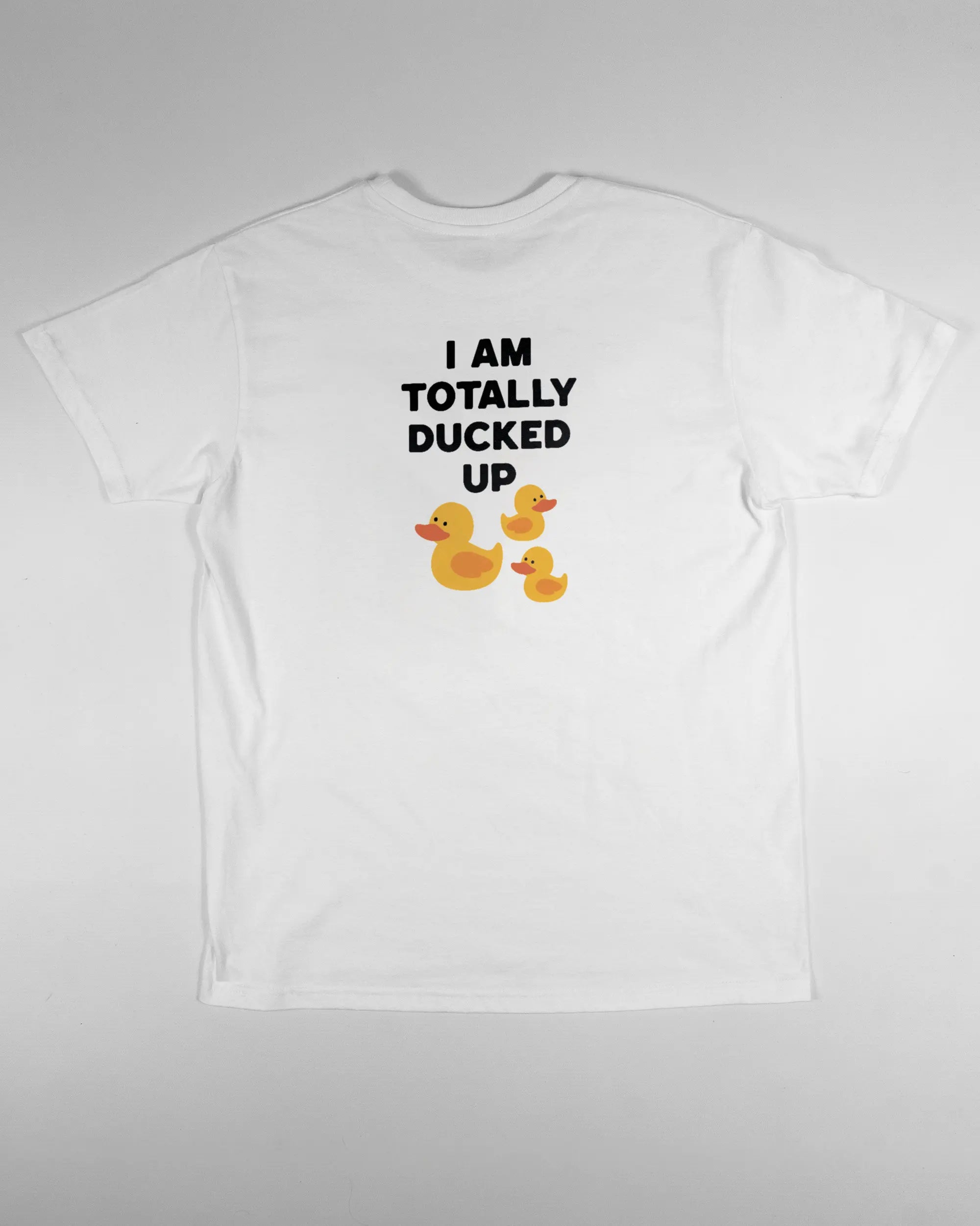 Rückseite des Basic Unisex T-Shirt Soft von Maondo mit dem Design Ducked Up in der Farbe White und in der Größe S flach auf den Boden gelegt