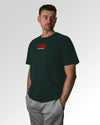 Männlicher Modelshot der primären Druckseite des Organic Unisex T-Shirts von Maondo im Relaxed Fit mit dem Design Authentic Shit in der Farbe Glazed Green