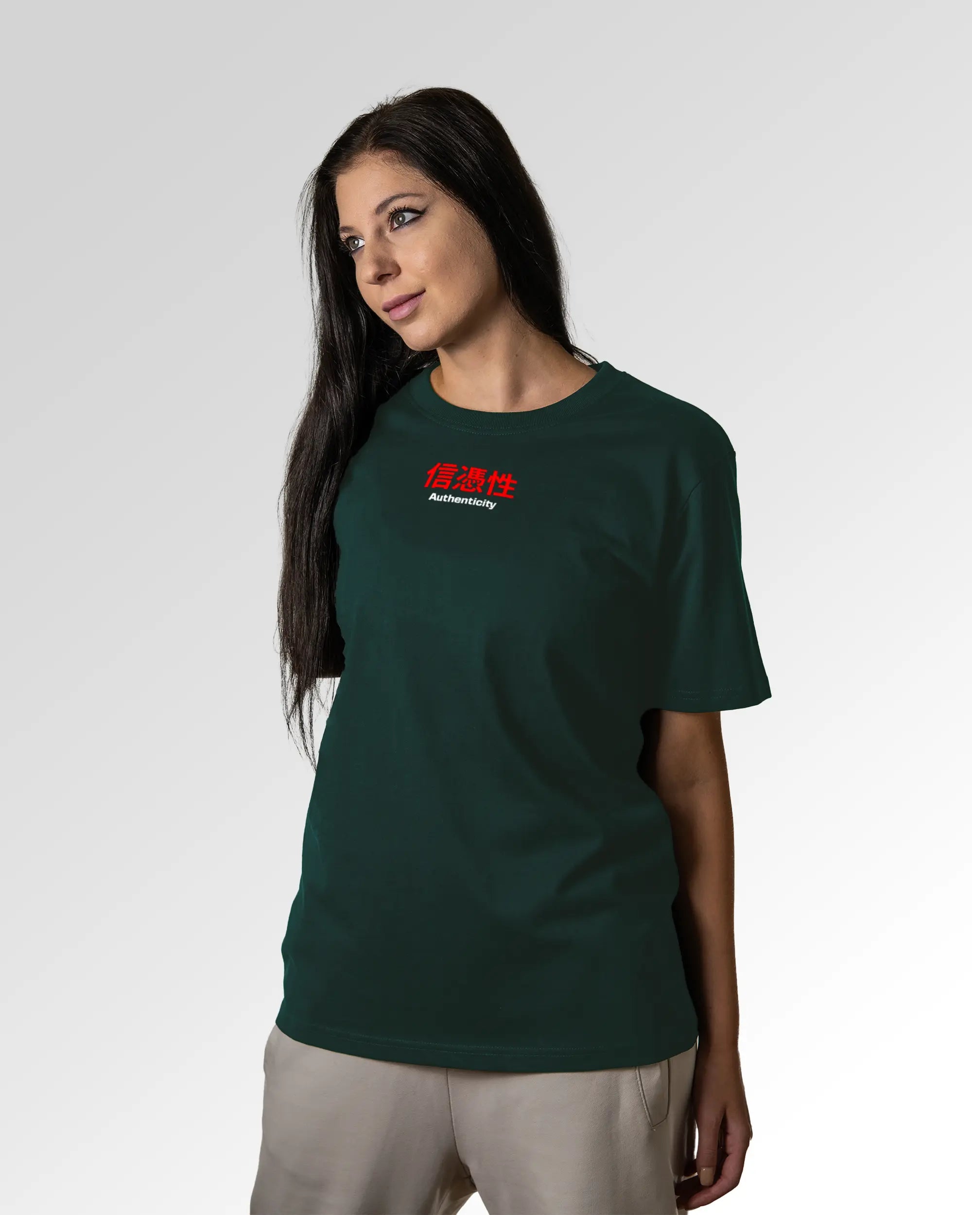 Weiblicher Modelshot der primären Druckseite des Organic Unisex T-Shirts von Maondo im Relaxed Fit mit dem Design Authentic Shit in der Farbe Glazed Green