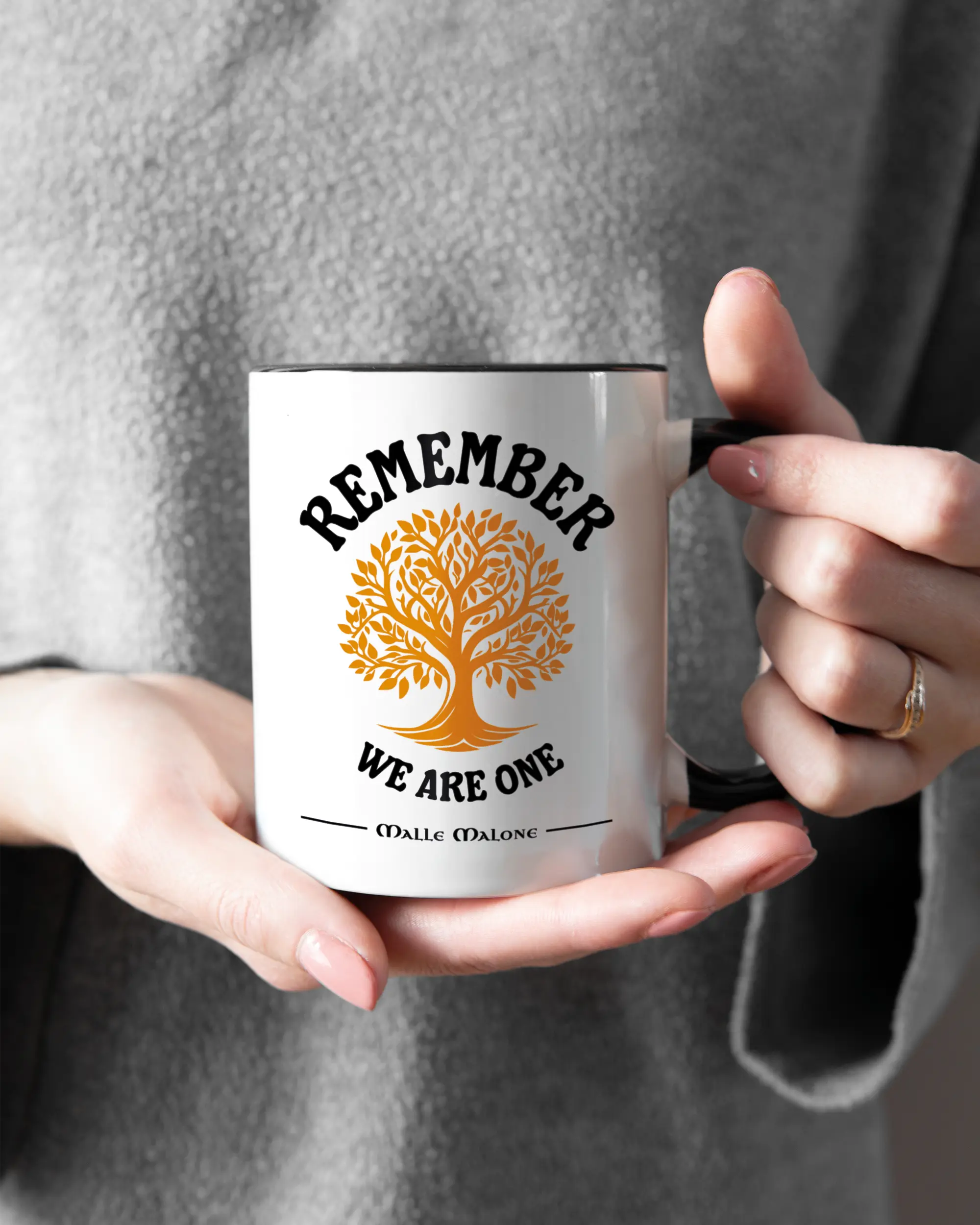 Rechte Seite der beidseitig bedruckten Keramiktasse von Maondo mit dem Design We are one in der Farbe Duotone gehalten von Frauenhänden