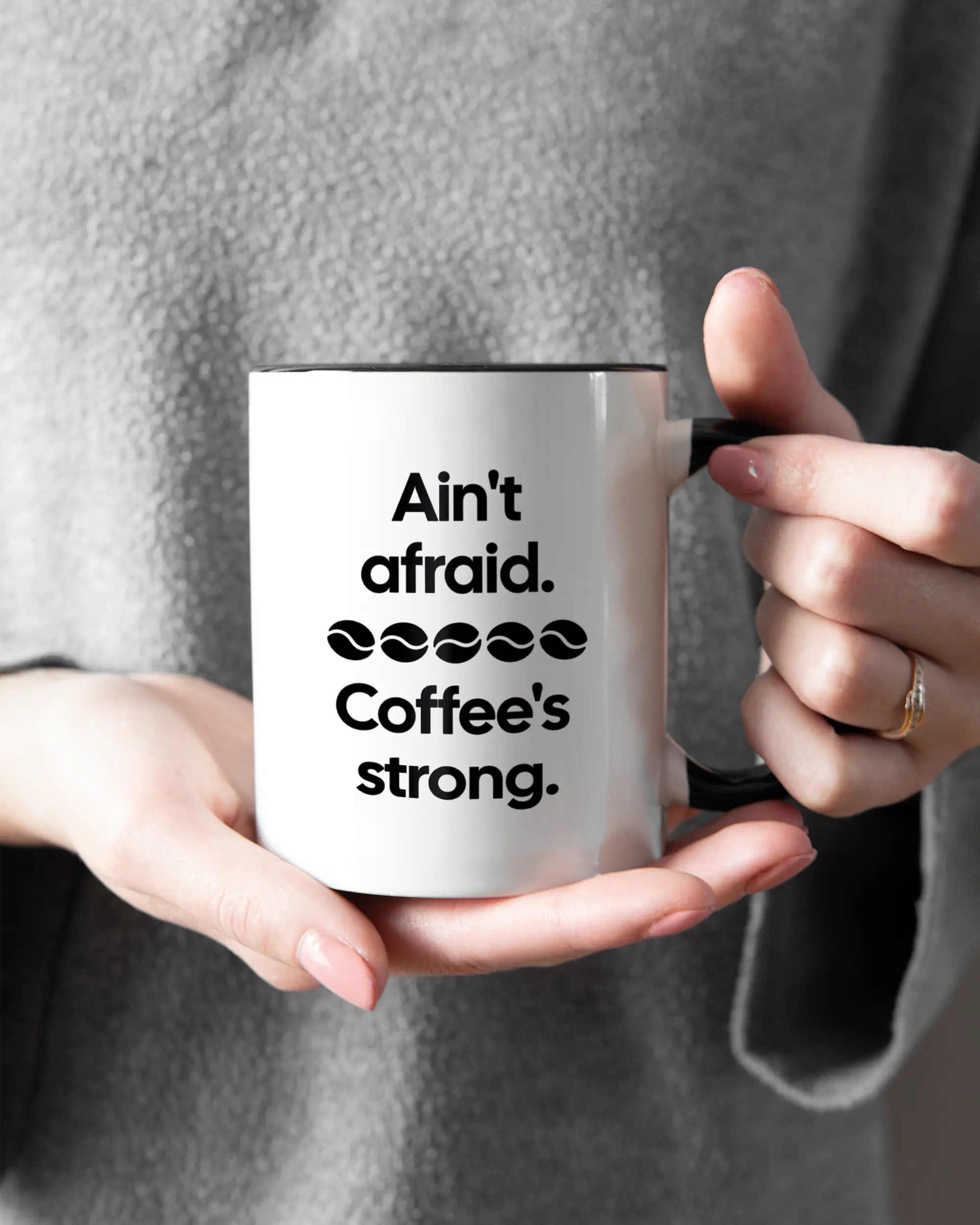 Rechte Seite der beidseitig bedruckten Keramiktasse von Maondo mit dem Design Coffee is strong in der Farbe Duotone gehalten von Frauenhänden