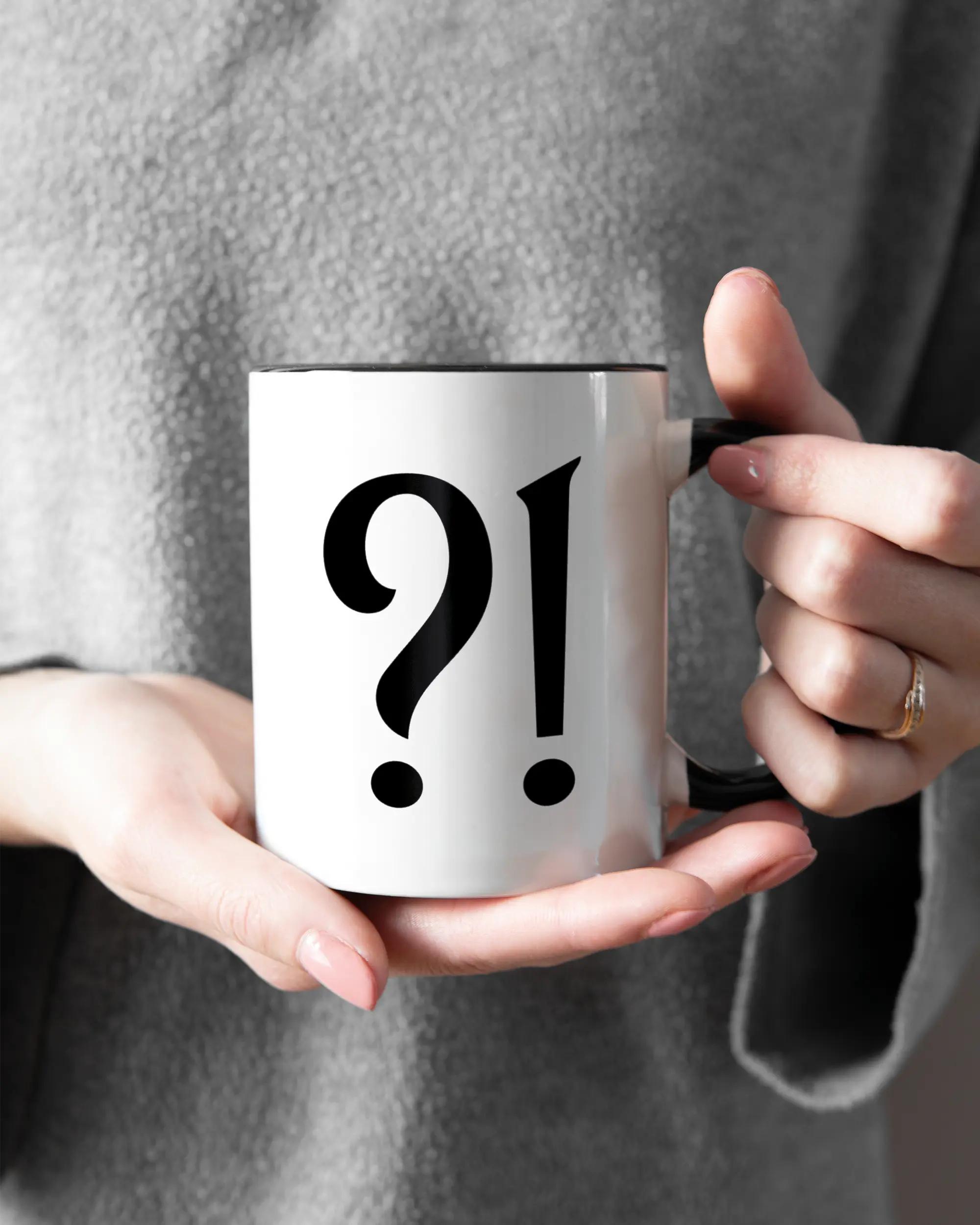 Rechte Seite der beidseitig bedruckten Keramiktasse von Maondo mit dem Design WHAT in der Farbe Duotone gehalten von Frauenhänden