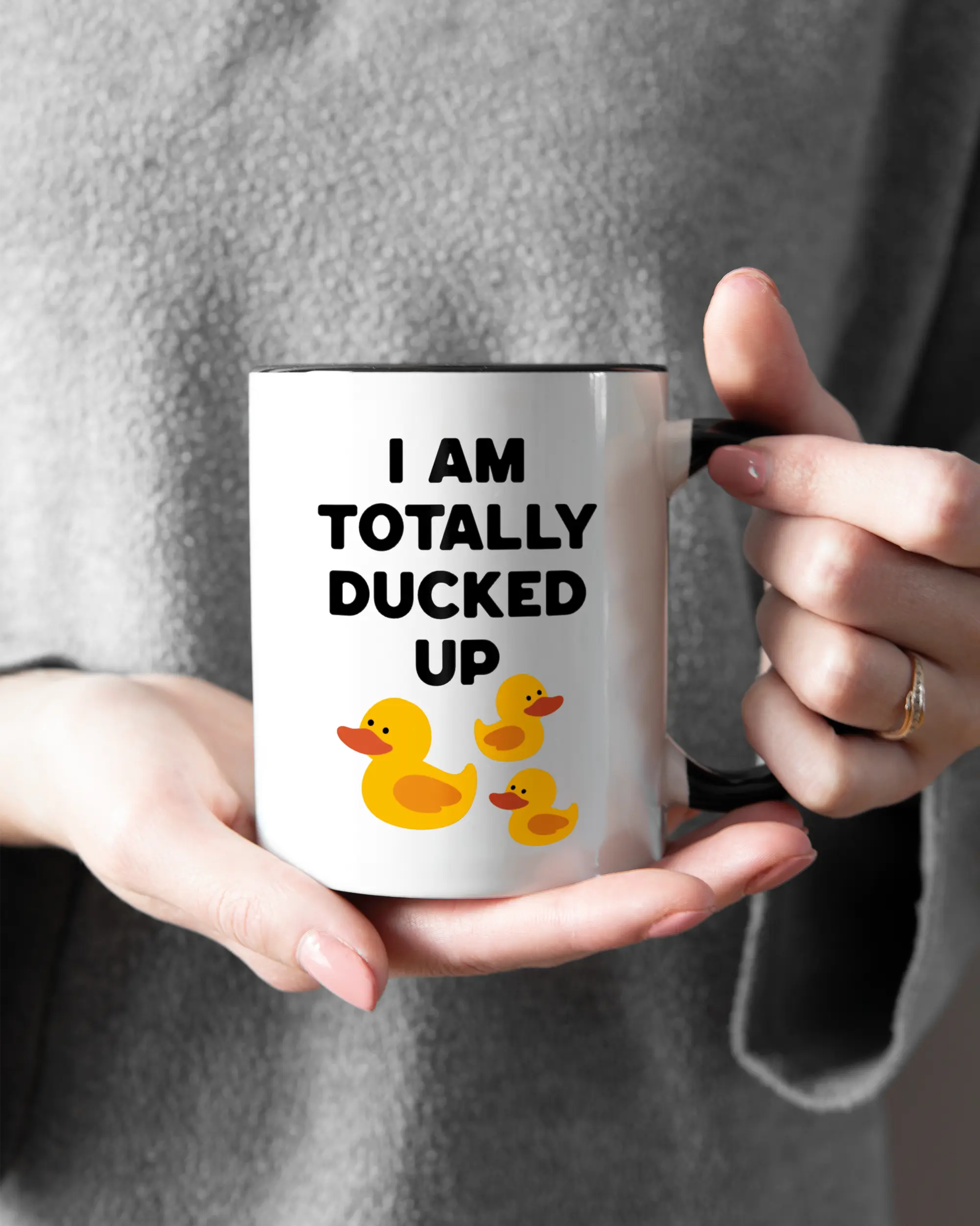 Rechte Seite der beidseitig bedruckten Keramiktasse von Maondo mit dem Design Ducked Up in der Farbe Duotone gehalten von Frauenhänden