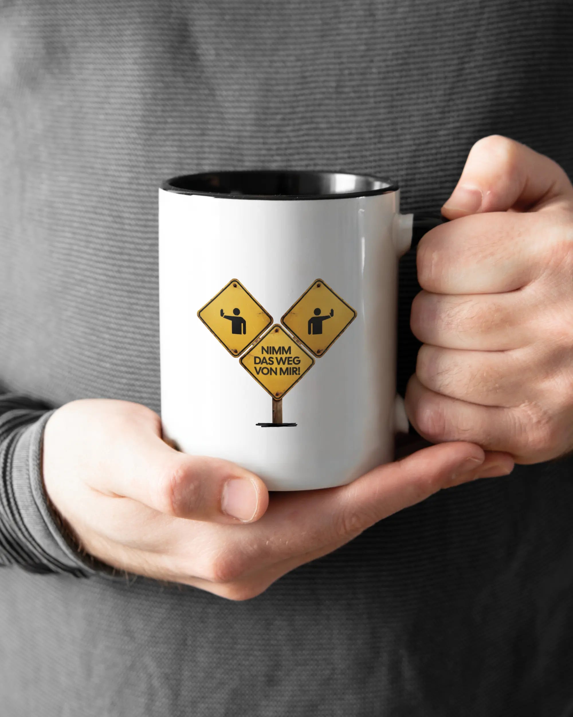 Rechte Seite der beidseitig bedruckten Keramiktasse von Maondo mit dem Design Schutzschild in der Farbe Duotone gehalten von Männerhänden