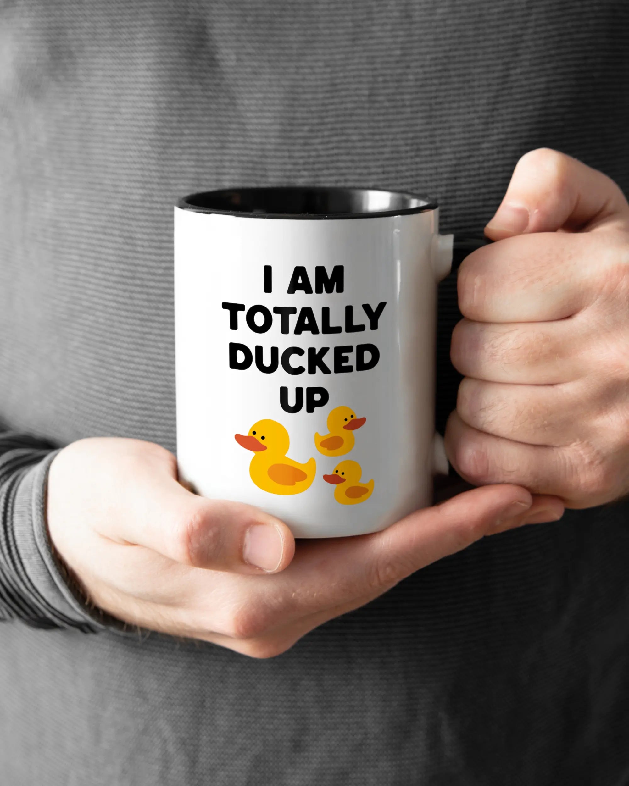 Rechte Seite der beidseitig bedruckten Keramiktasse von Maondo mit dem Design Ducked Up in der Farbe Duotone gehalten von Männerhänden