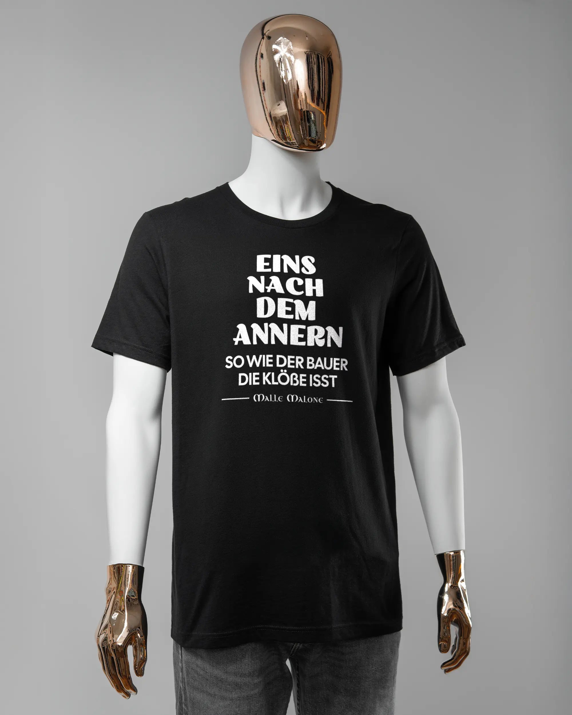 Vorderseite des Basic Unisex T-Shirt Light von Maondo mit dem Design Eins nach dem Annern in der Farbe Black und in der Größe L getragen von einer maskulinen Puppe