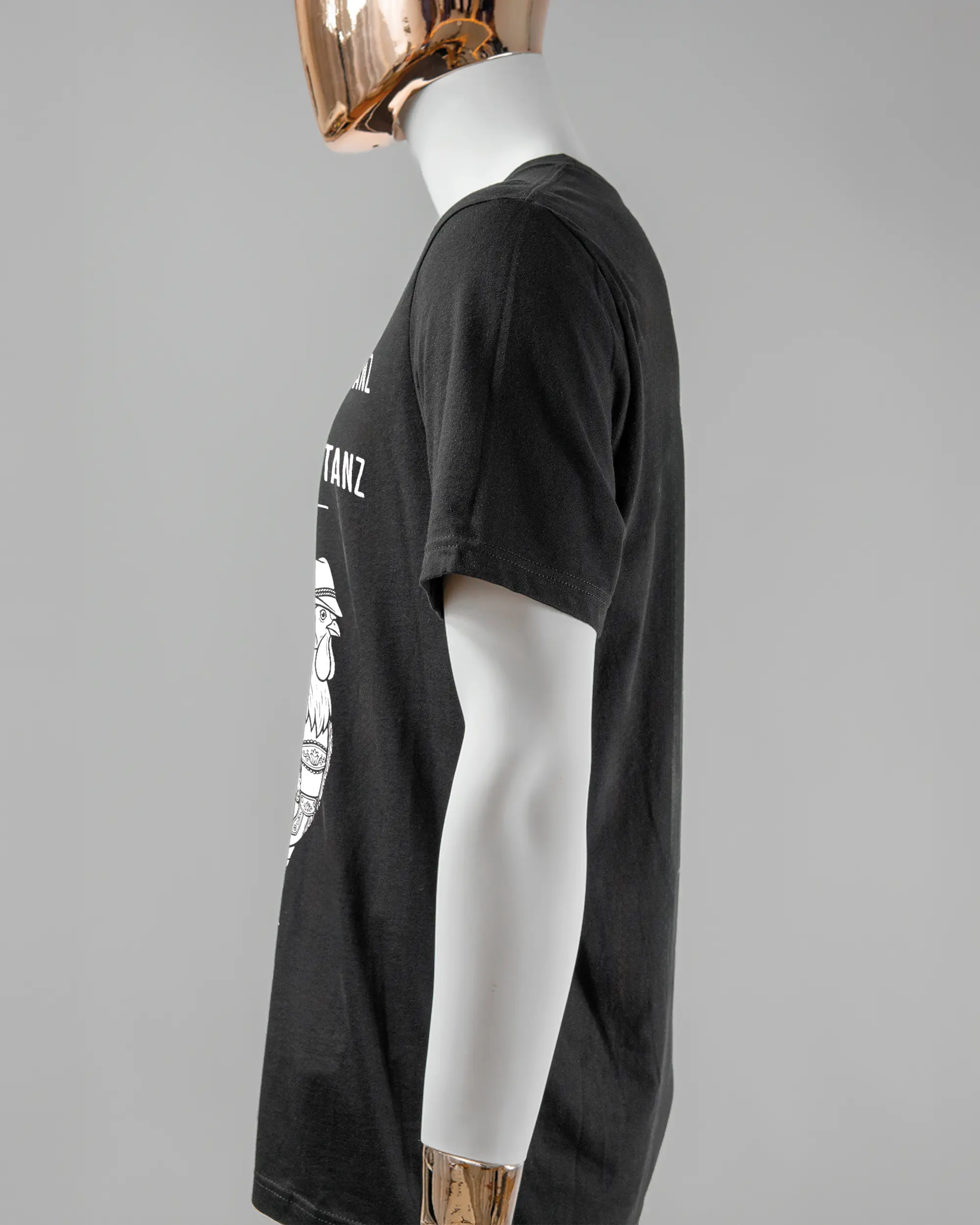 Seitenansicht des Basic Unisex T-Shirt Light von Maondo mit dem Design Trachtentanz vorne in der Farbe Black und in der Größe L getragen von einer maskulinen Puppe
