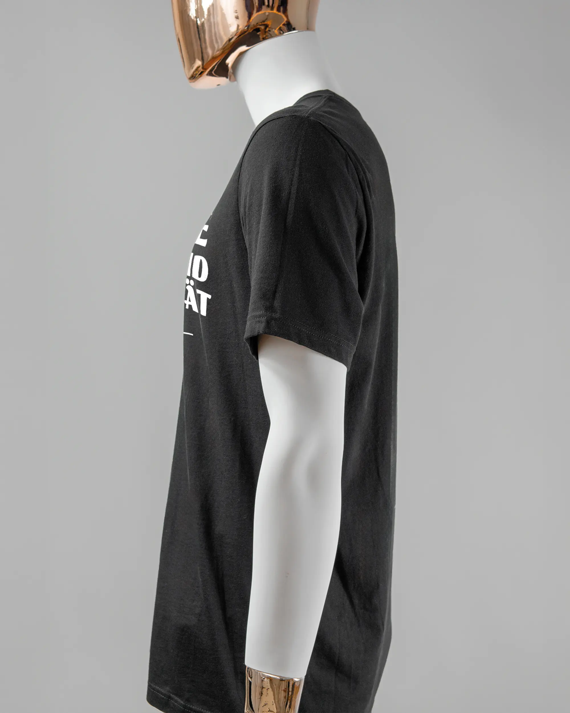Seitenansicht des Basic Unisex T-Shirt Light von Maondo mit dem Design Keine Eile vorne in der Farbe Black und in der Größe L getragen von einer maskulinen Puppe